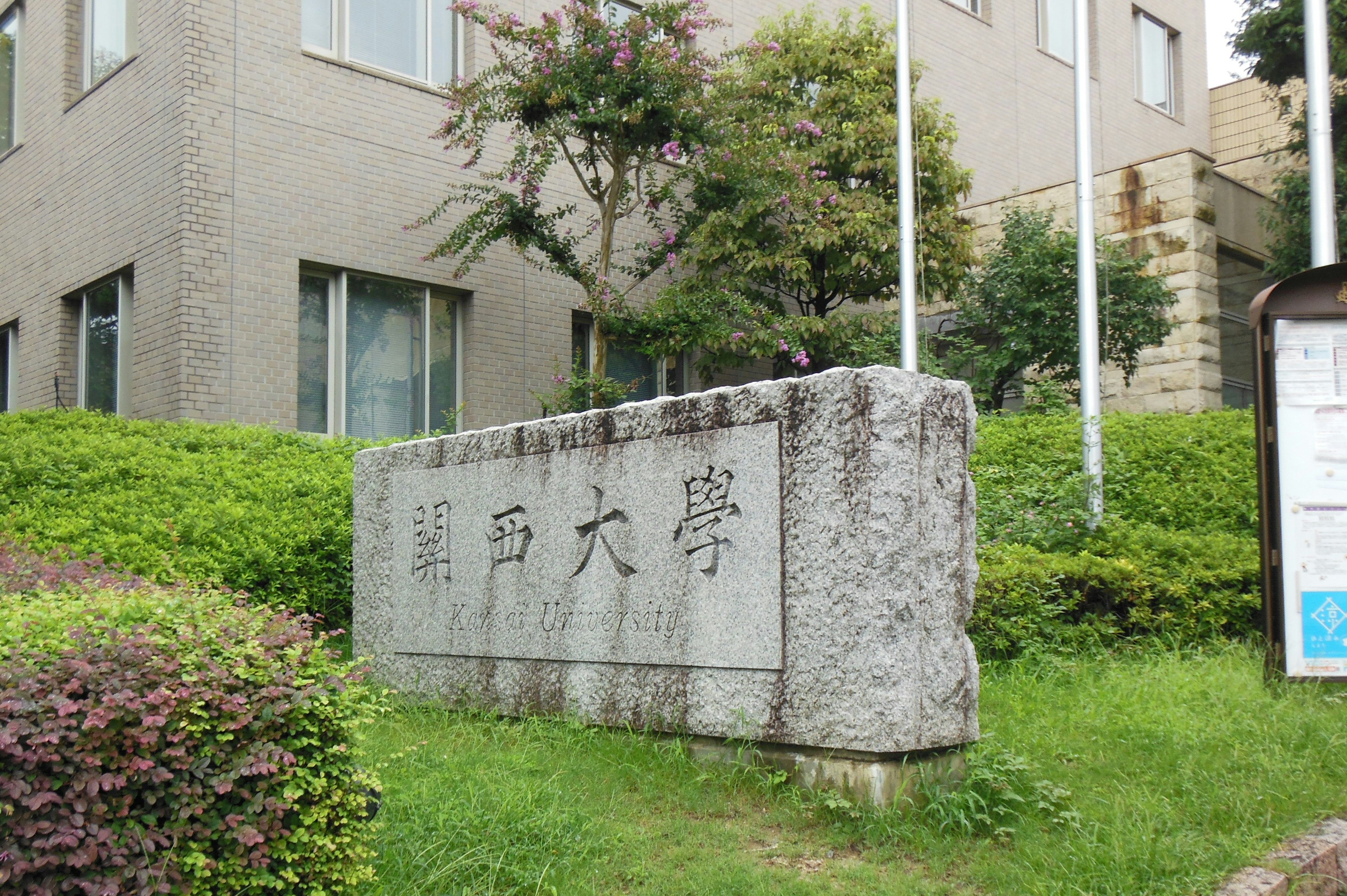 Stone monument of a university with greenery