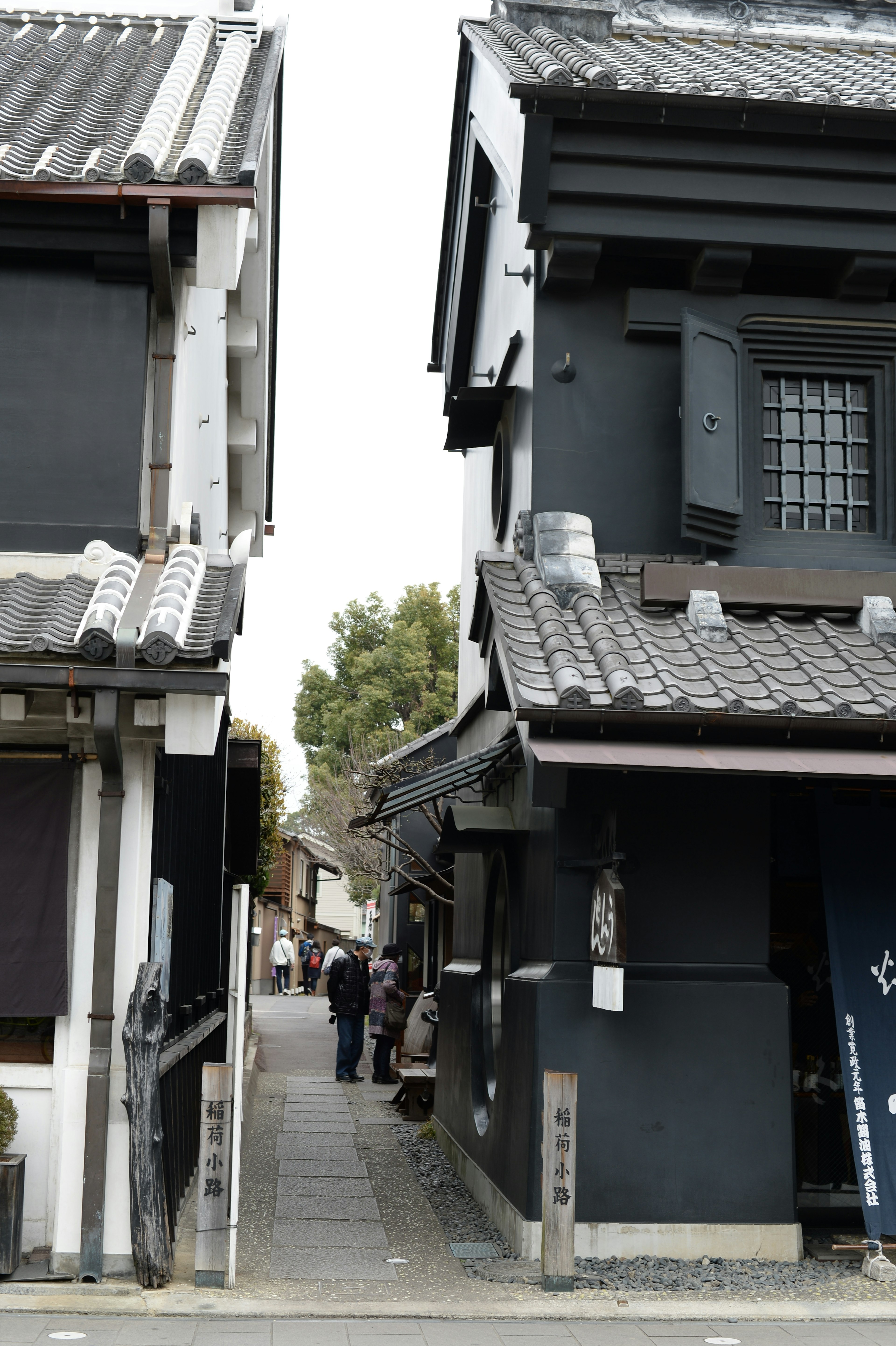 Calle estrecha flanqueada por casas japonesas tradicionales con fachadas negras