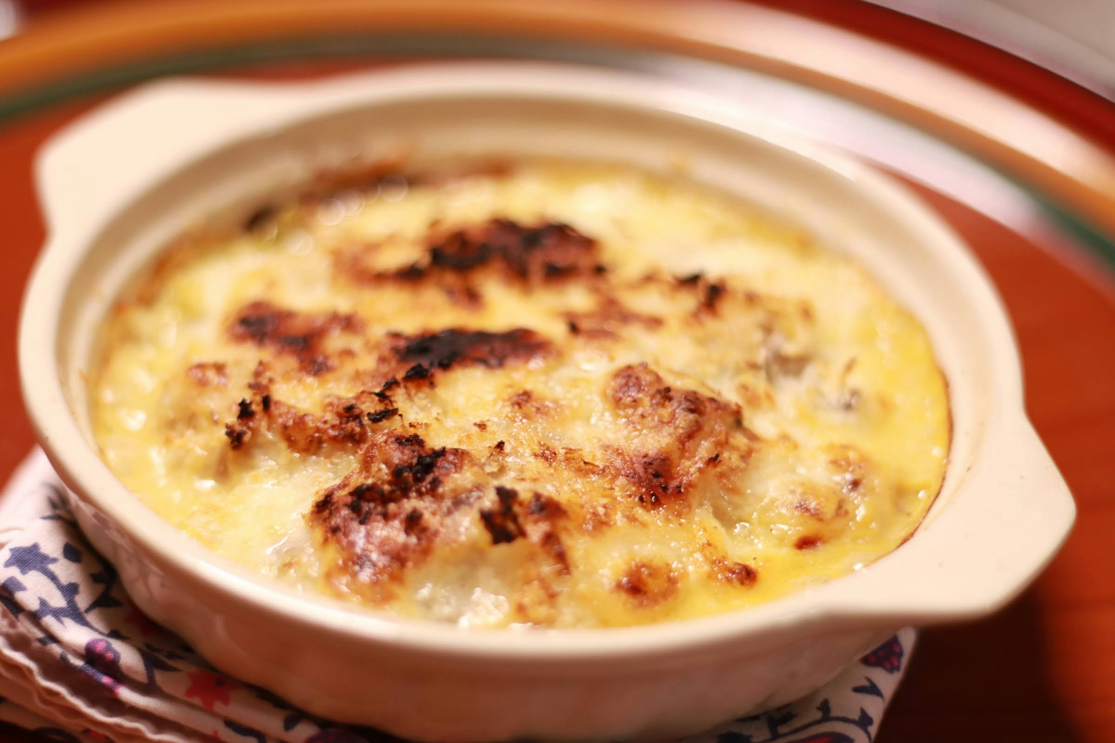 Gratin cremoso con corteza dorada en un plato de cerámica