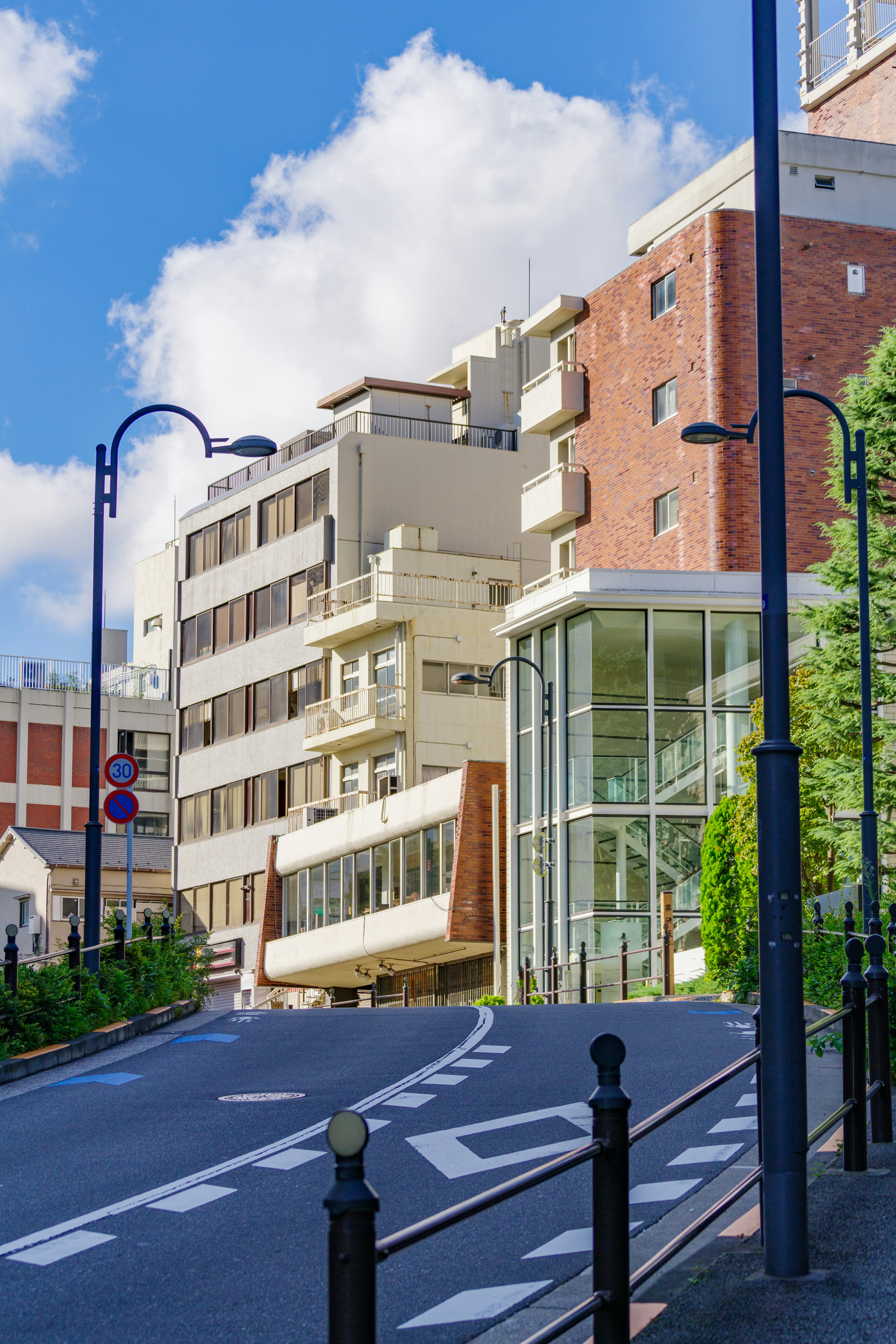 Vue de rue en pente avec des bâtiments modernes sous un ciel bleu