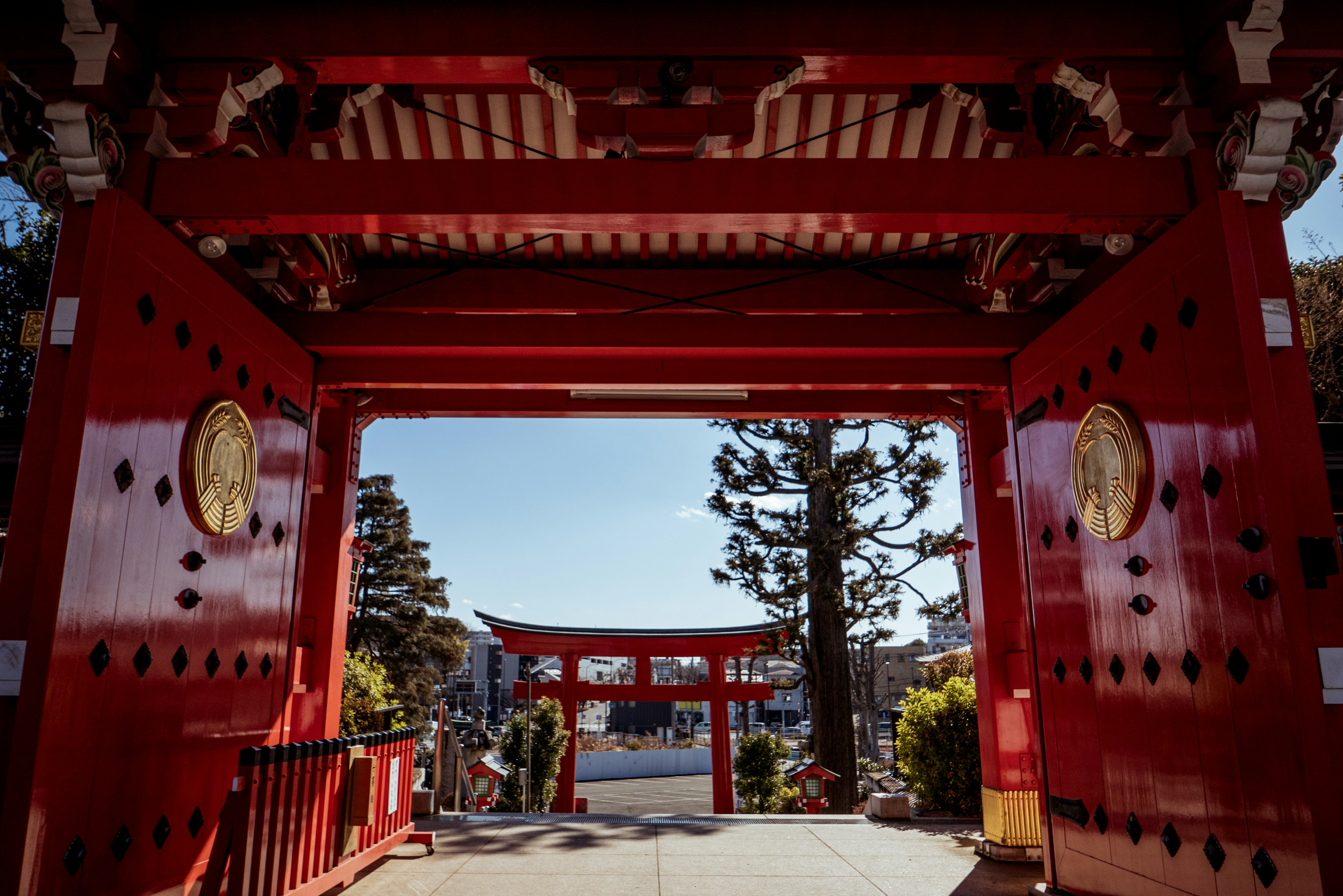 Rote Tür mit einem Torii im Hintergrund