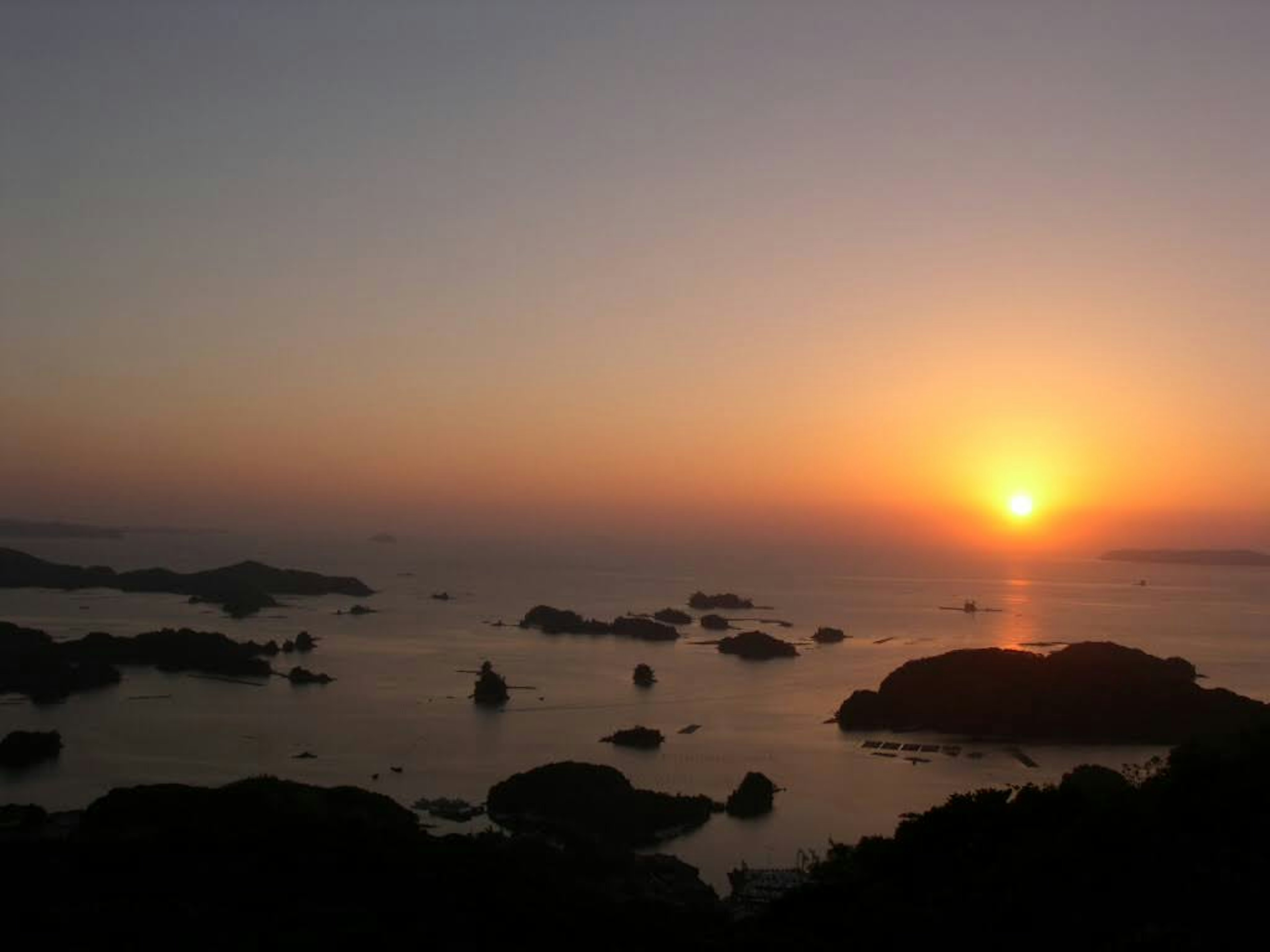 美麗的日落映照在海面上，岩石海岸線