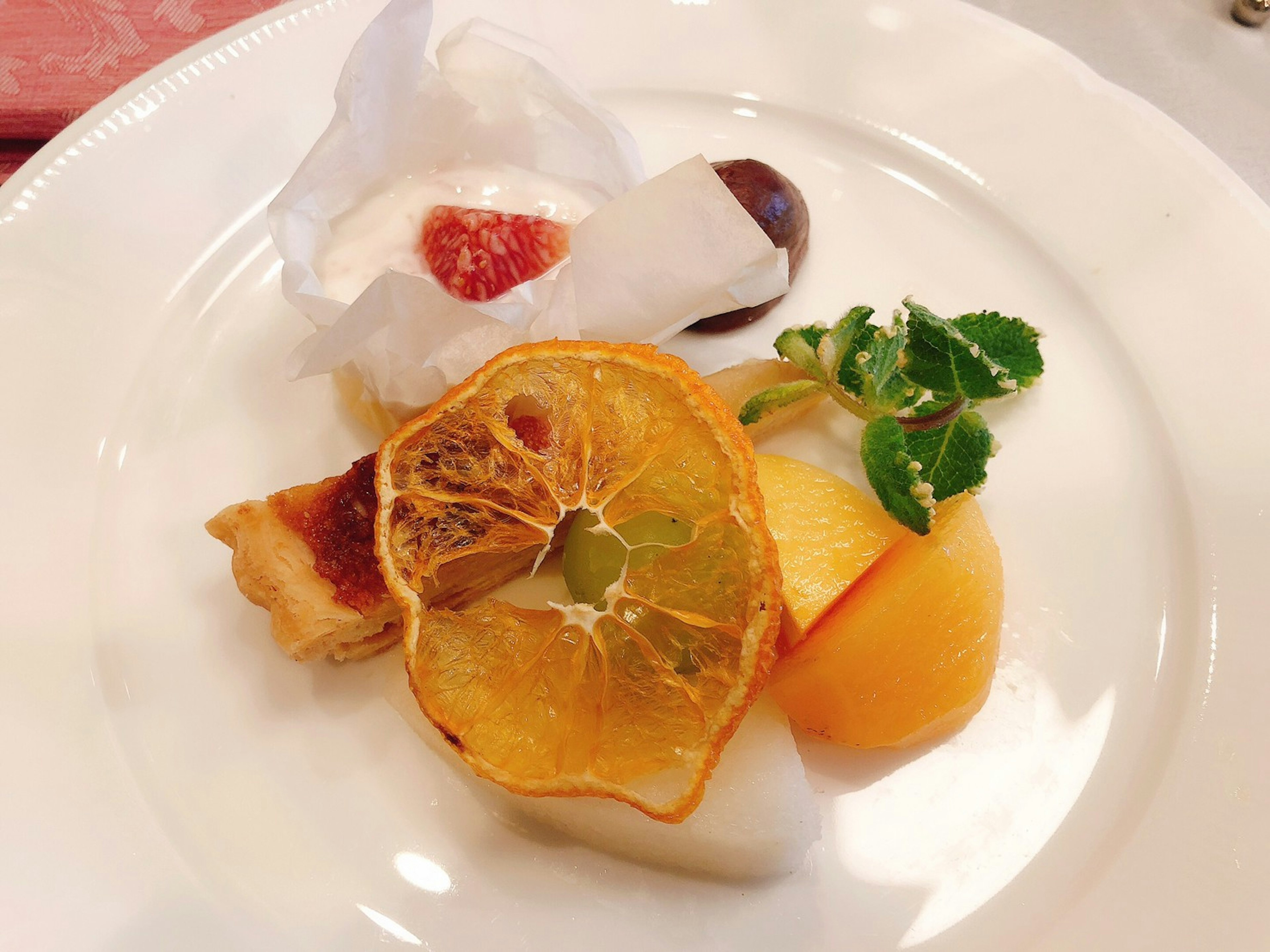 A beautifully plated dessert featuring assorted fruits and cream