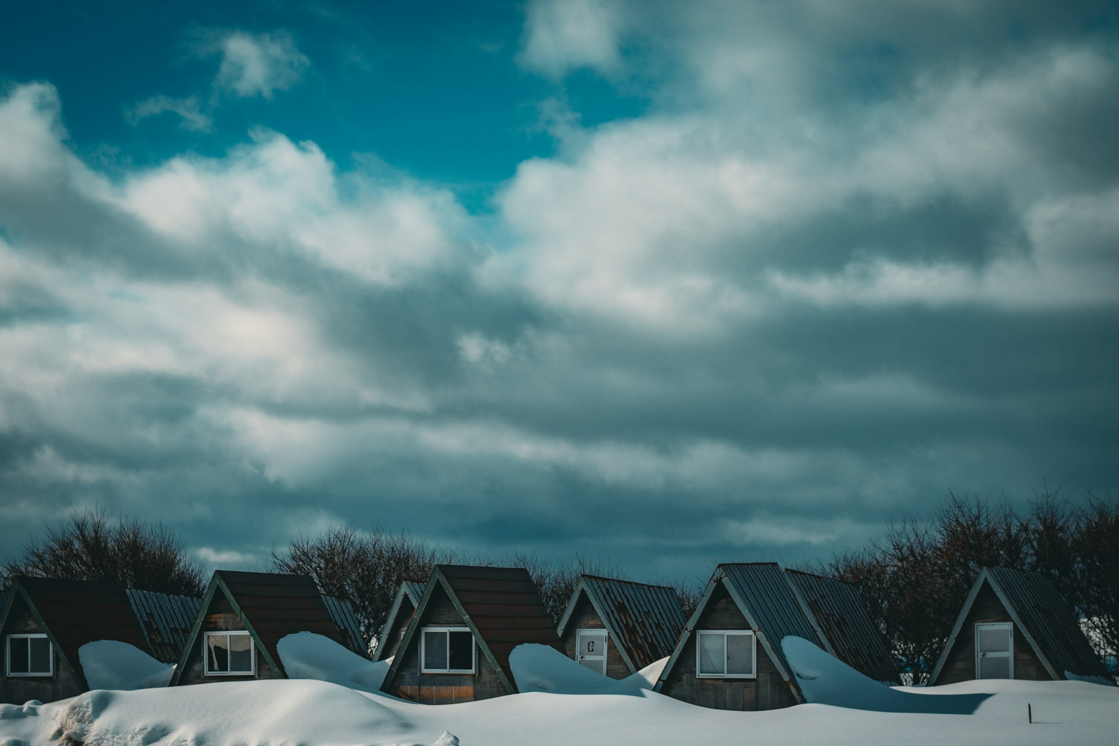 Fila de cabañas cubiertas de nieve bajo un cielo nublado