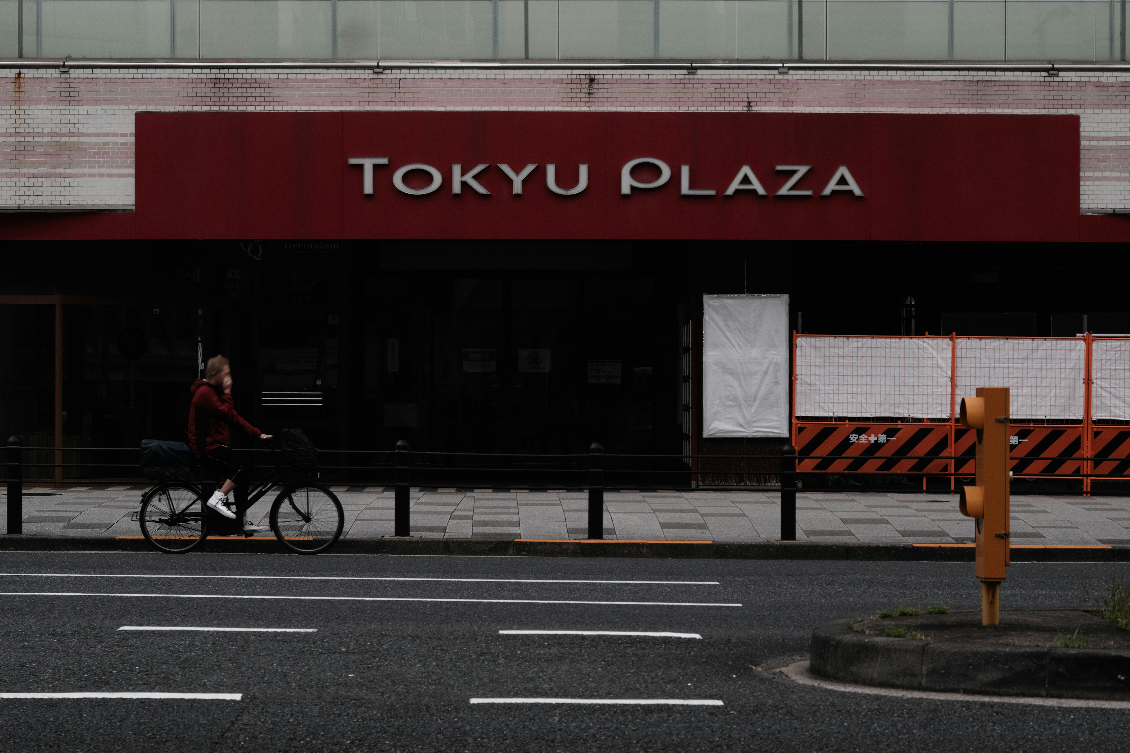 Tanda Tokyu Plaza dengan seseorang yang mengendarai sepeda