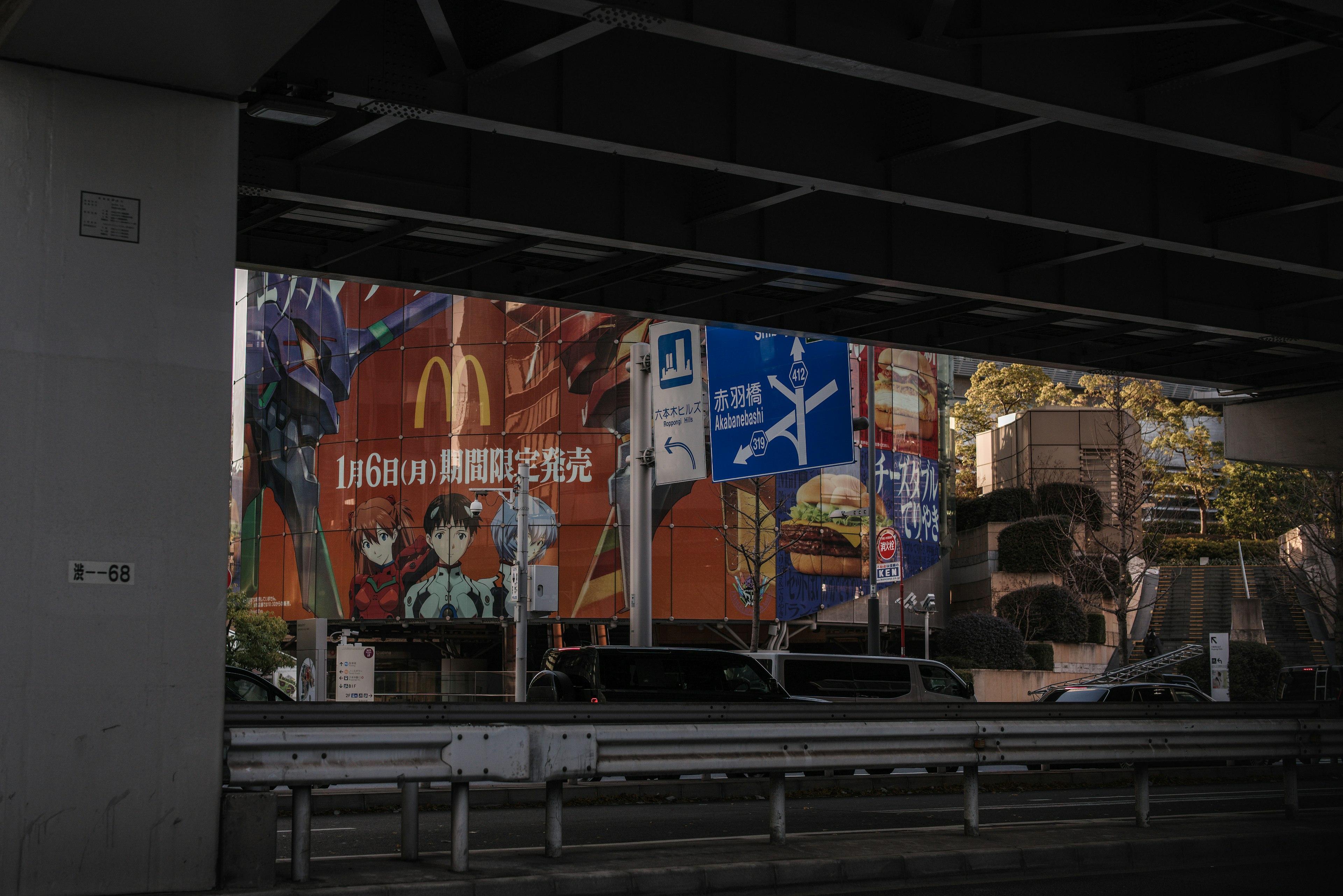 Advertising billboards and cityscape under a bridge