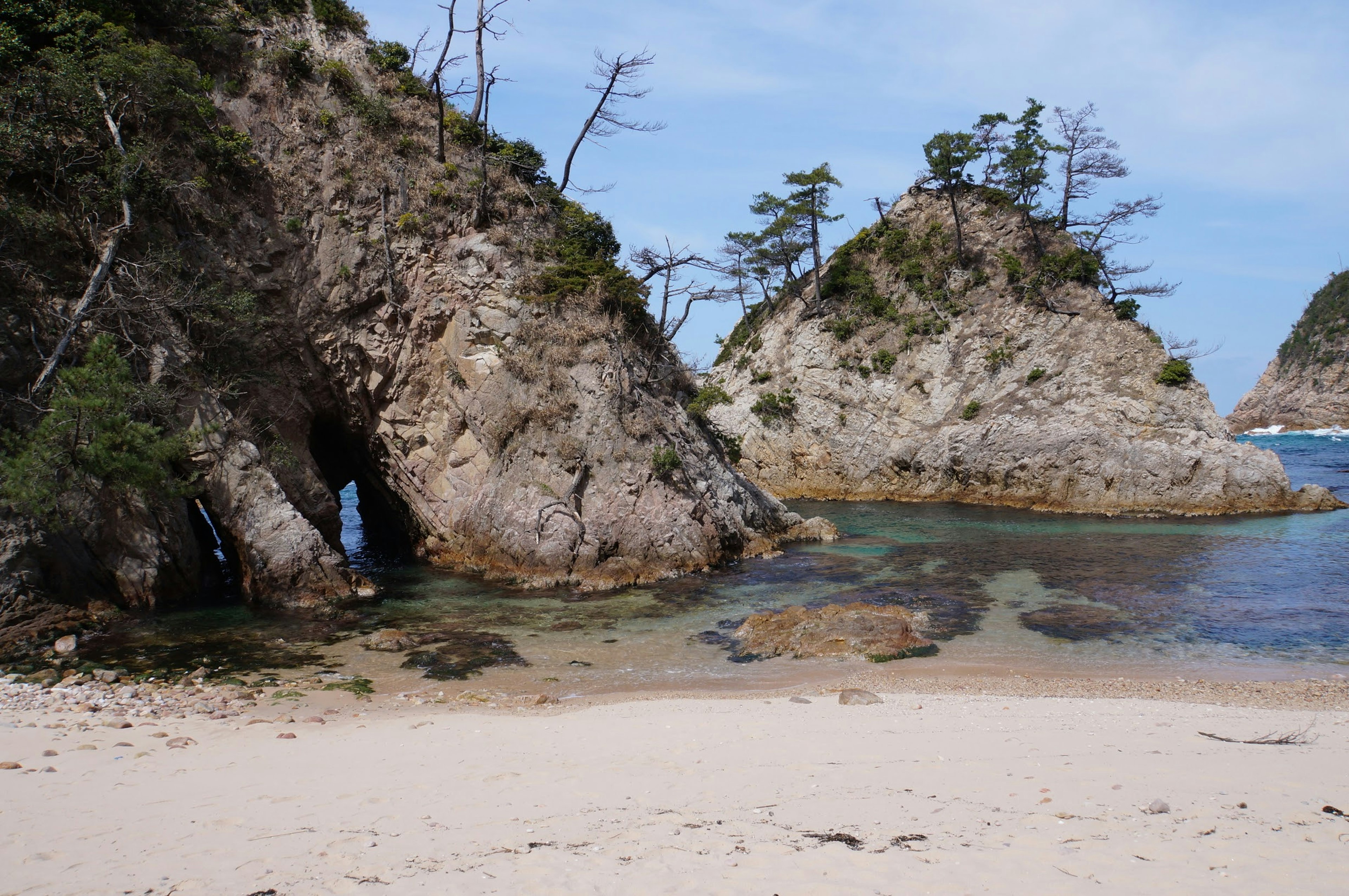 Plage pittoresque avec formations rocheuses et eau claire