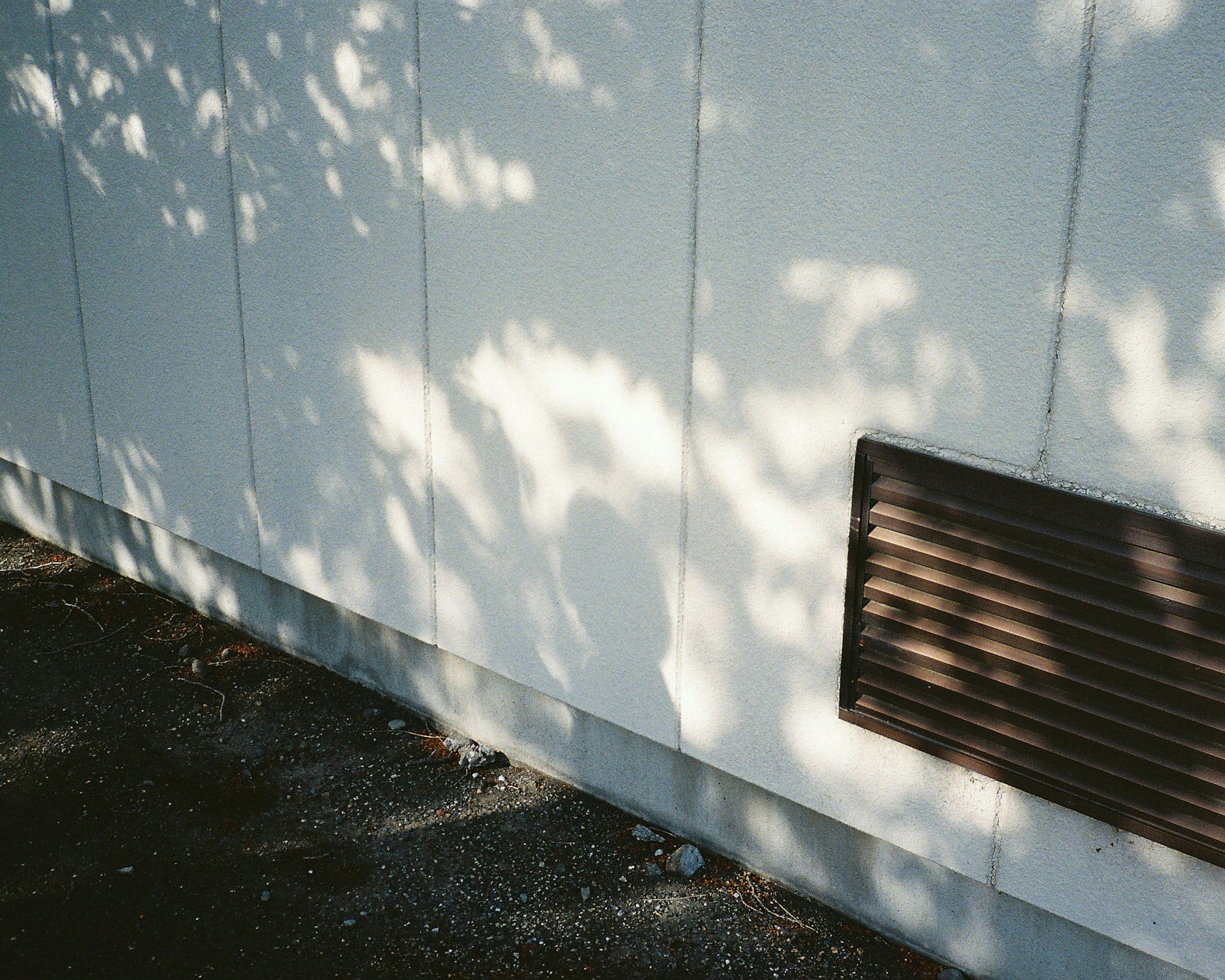 Ombres projetées sur un mur blanc avec une ventilation