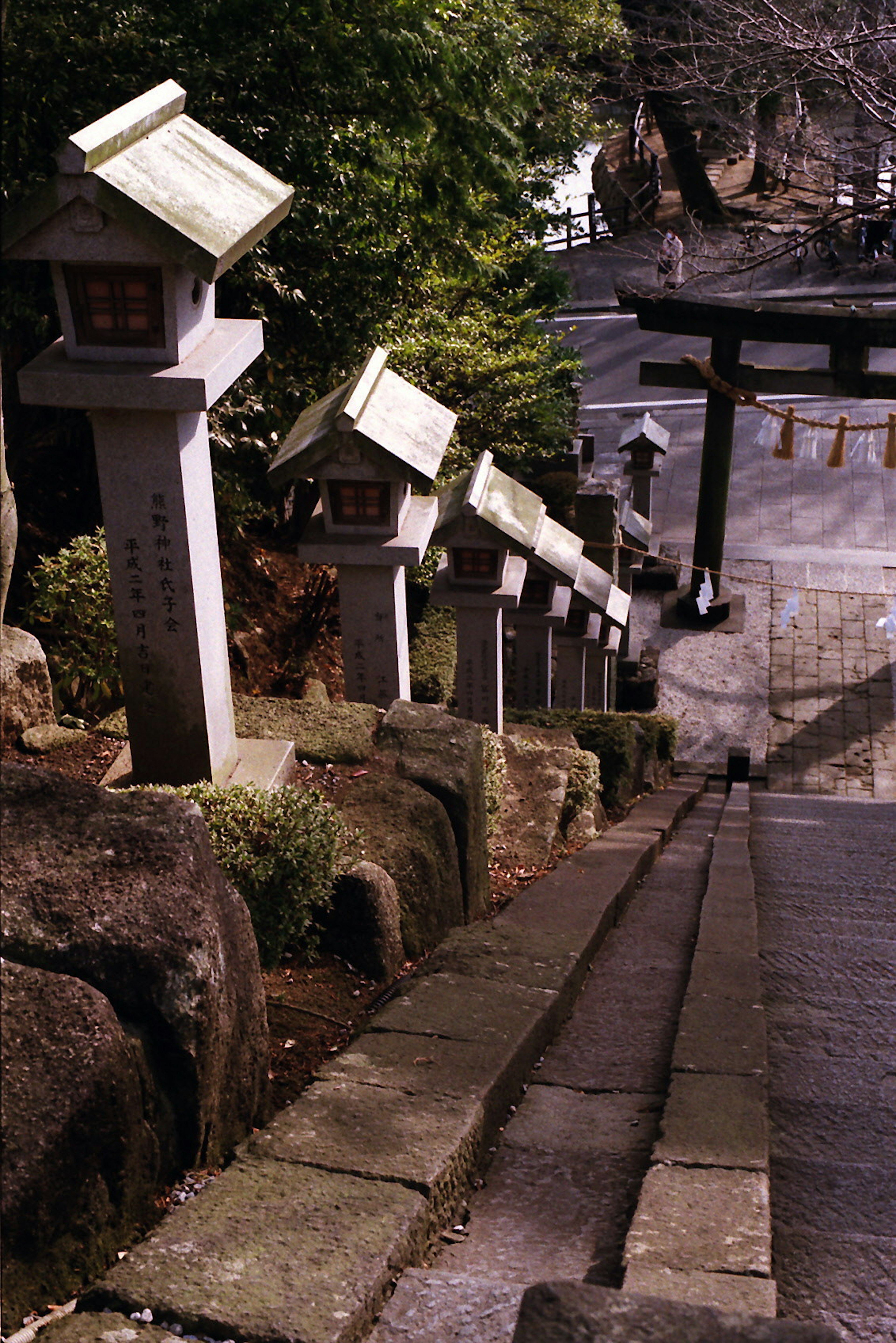 Lanterne di pietra lungo una scalinata che conduce a un torii