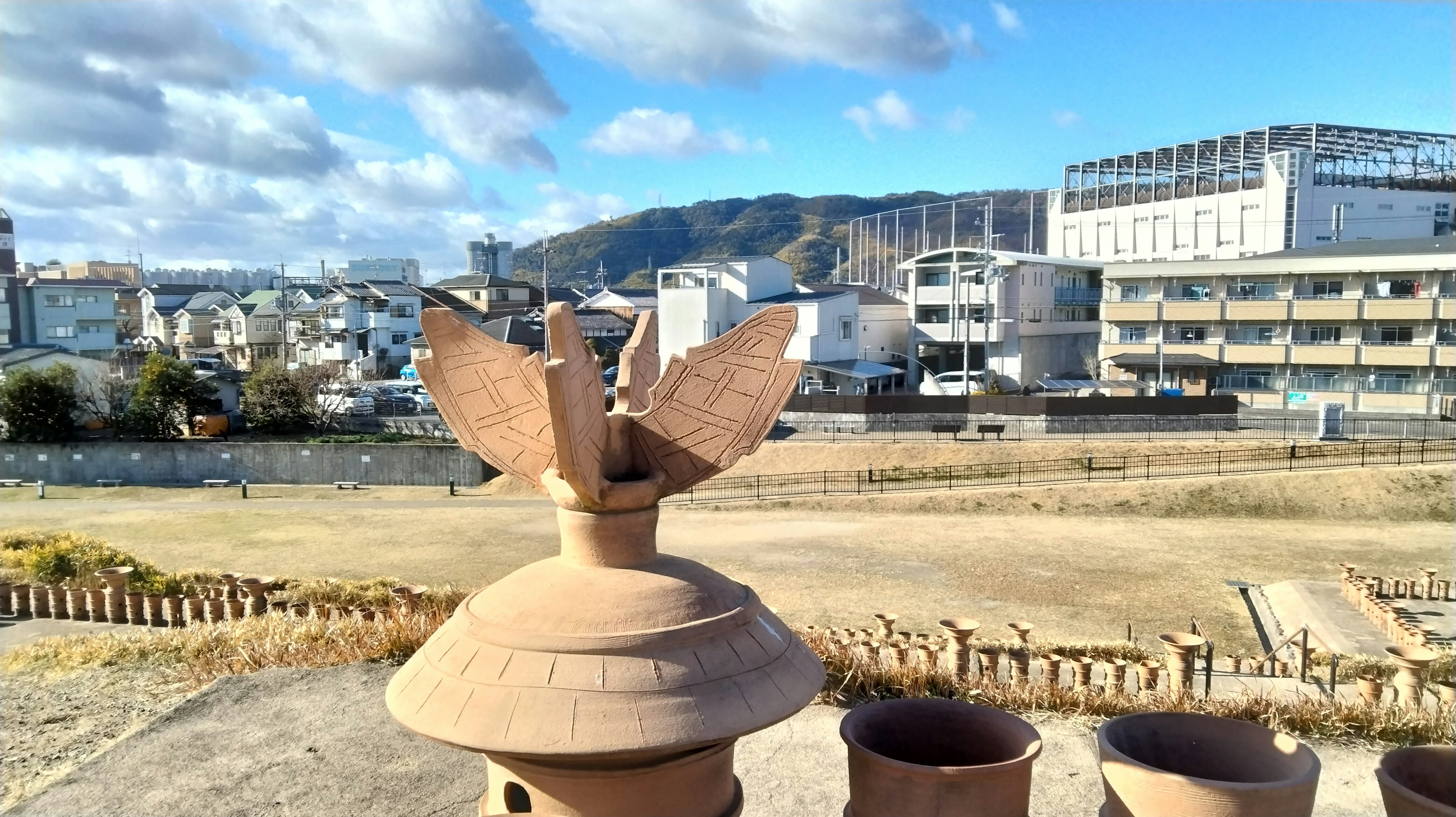 Decorative pottery jar in the foreground with a cityscape and mountains in the background