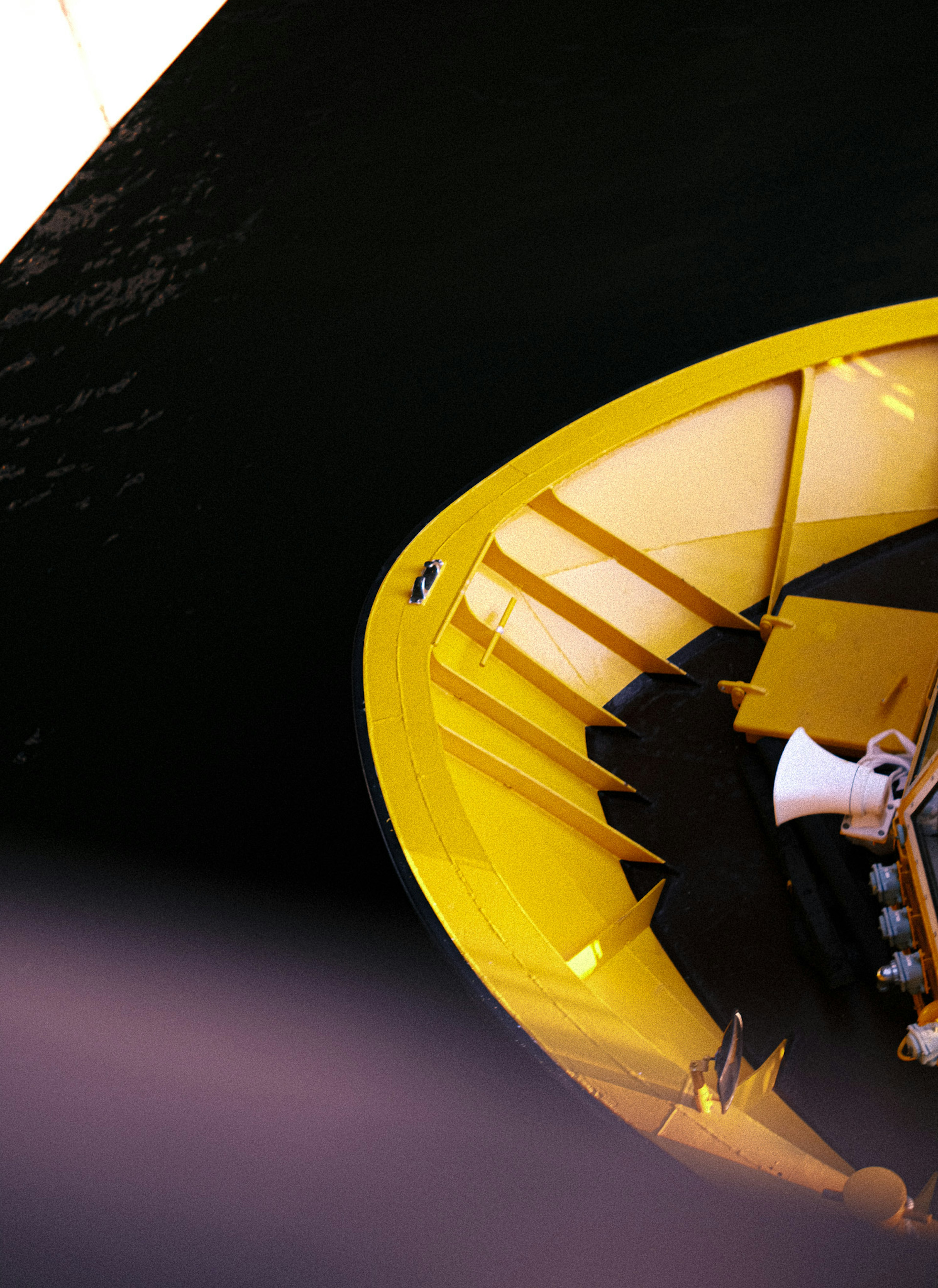 A yellow boat staircase with a part of the black water surface visible