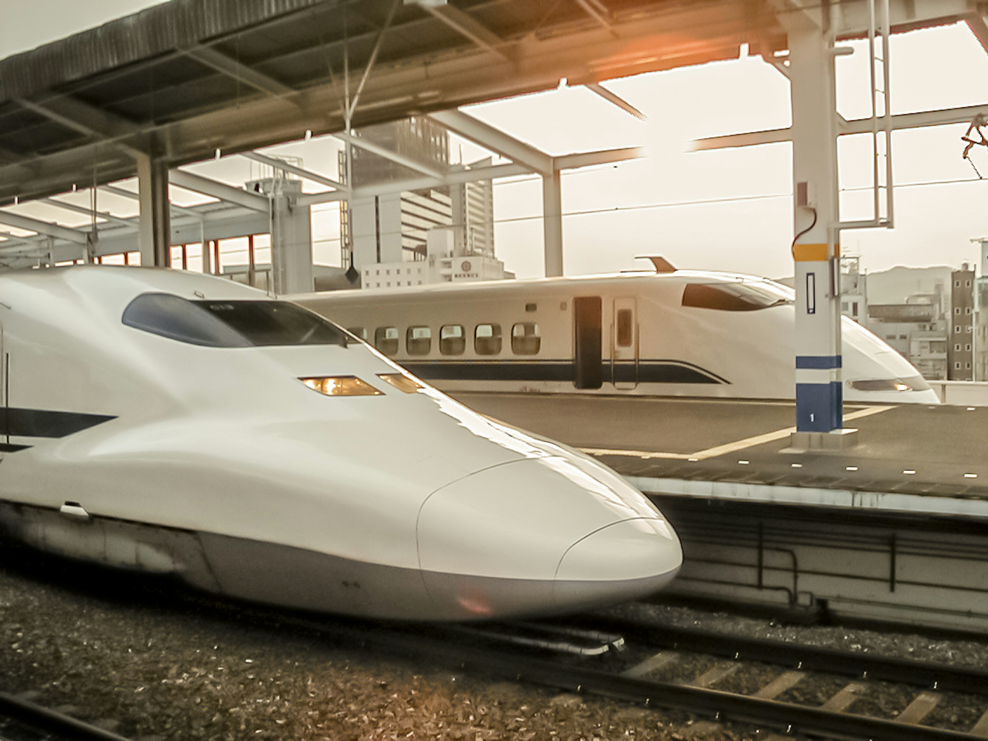 Shinkansen parked at a station featuring a sleek white body and modern design