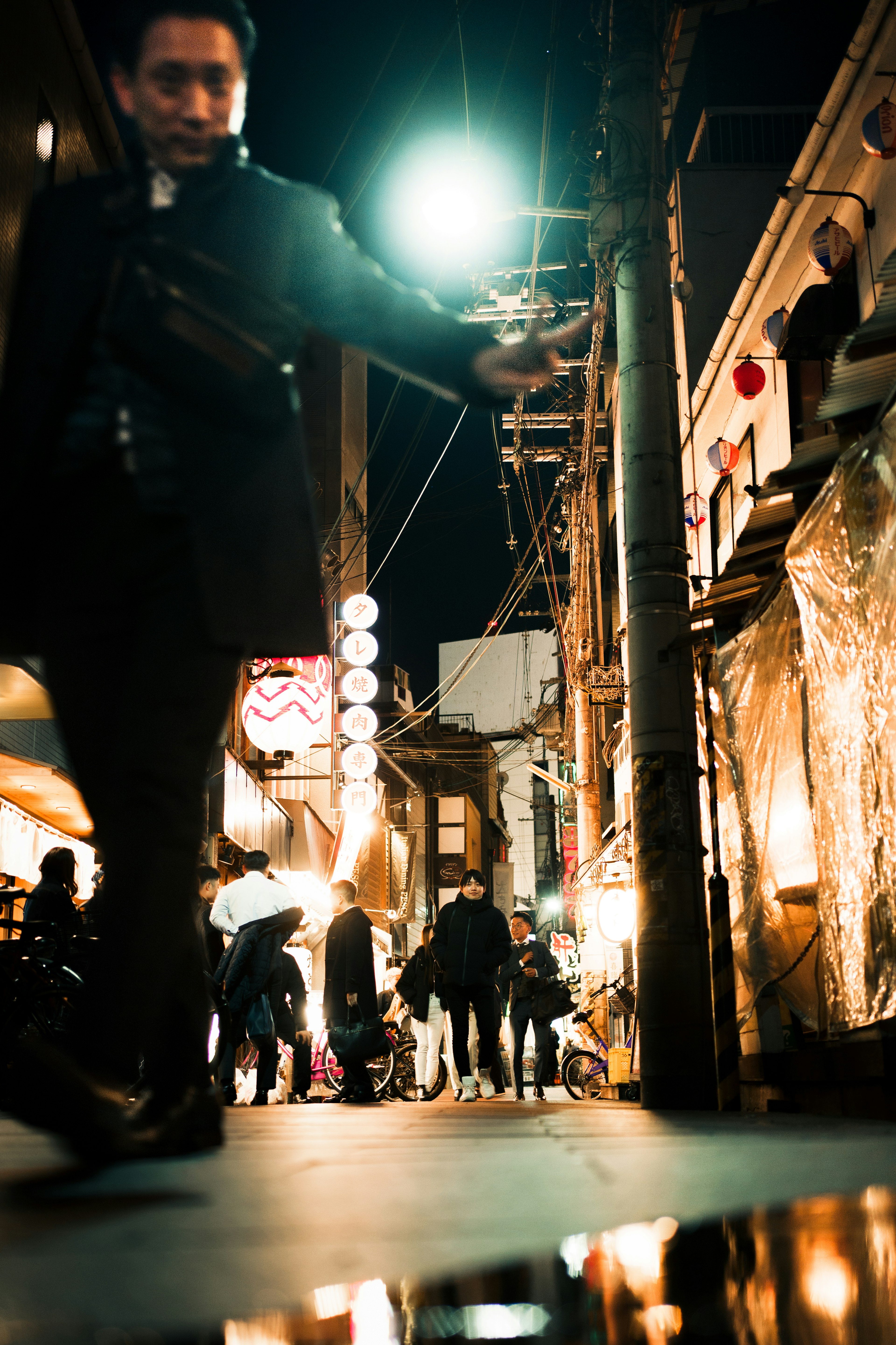 繁忙的夜间街道场景，有行人和闪烁的灯光