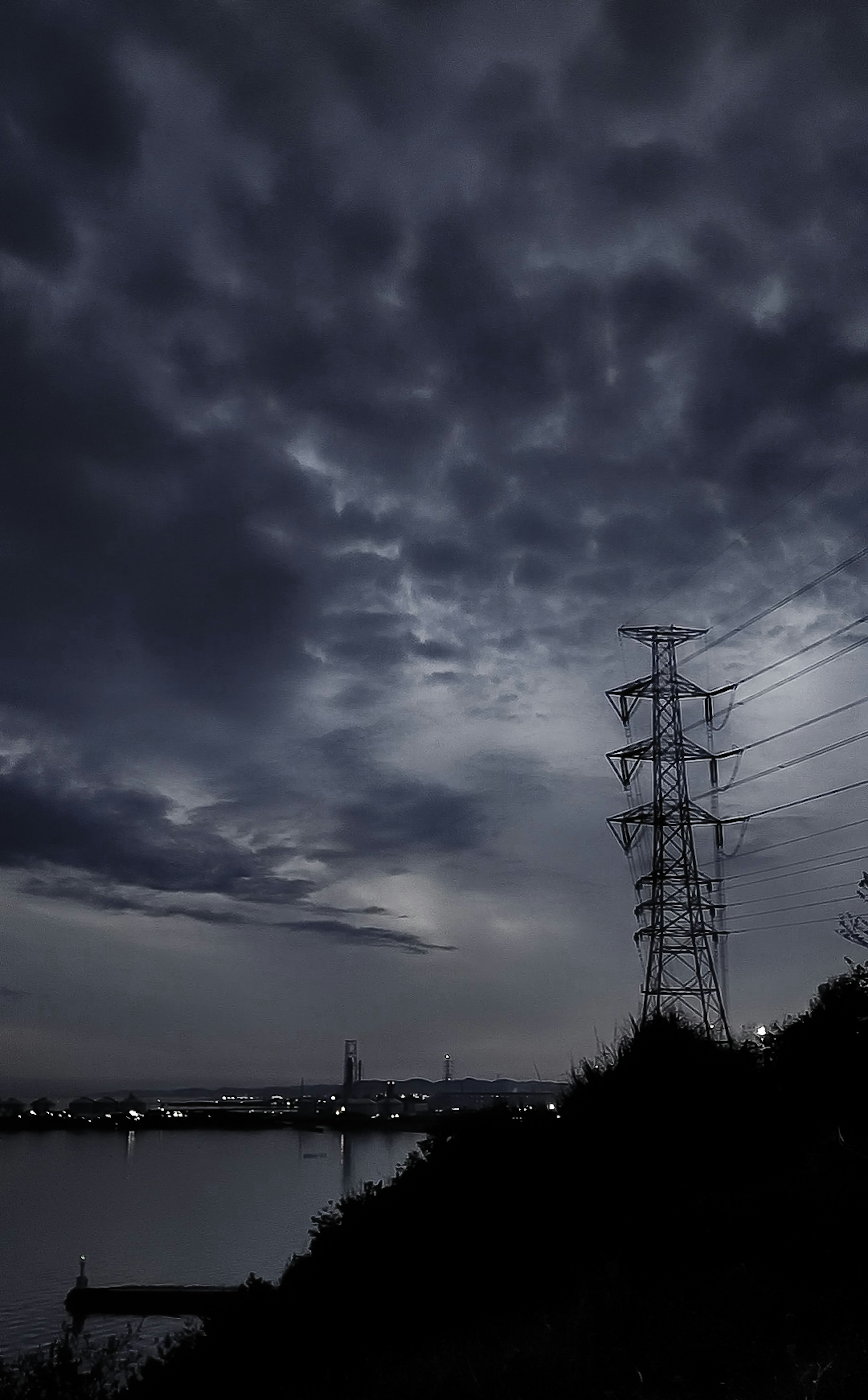 暗い空と電柱が映る風景の写真