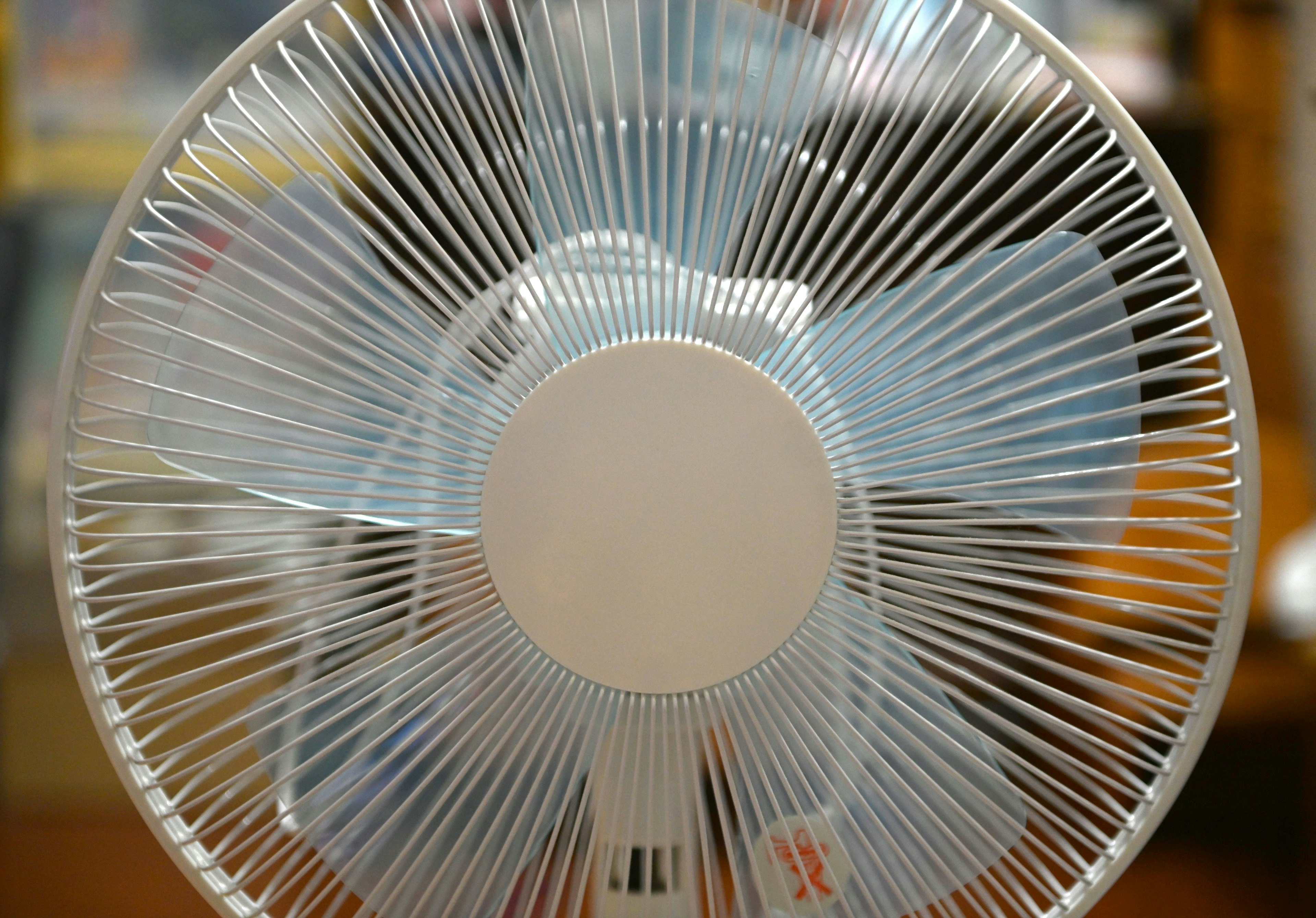 Close-up of a transparent fan with a blurred background