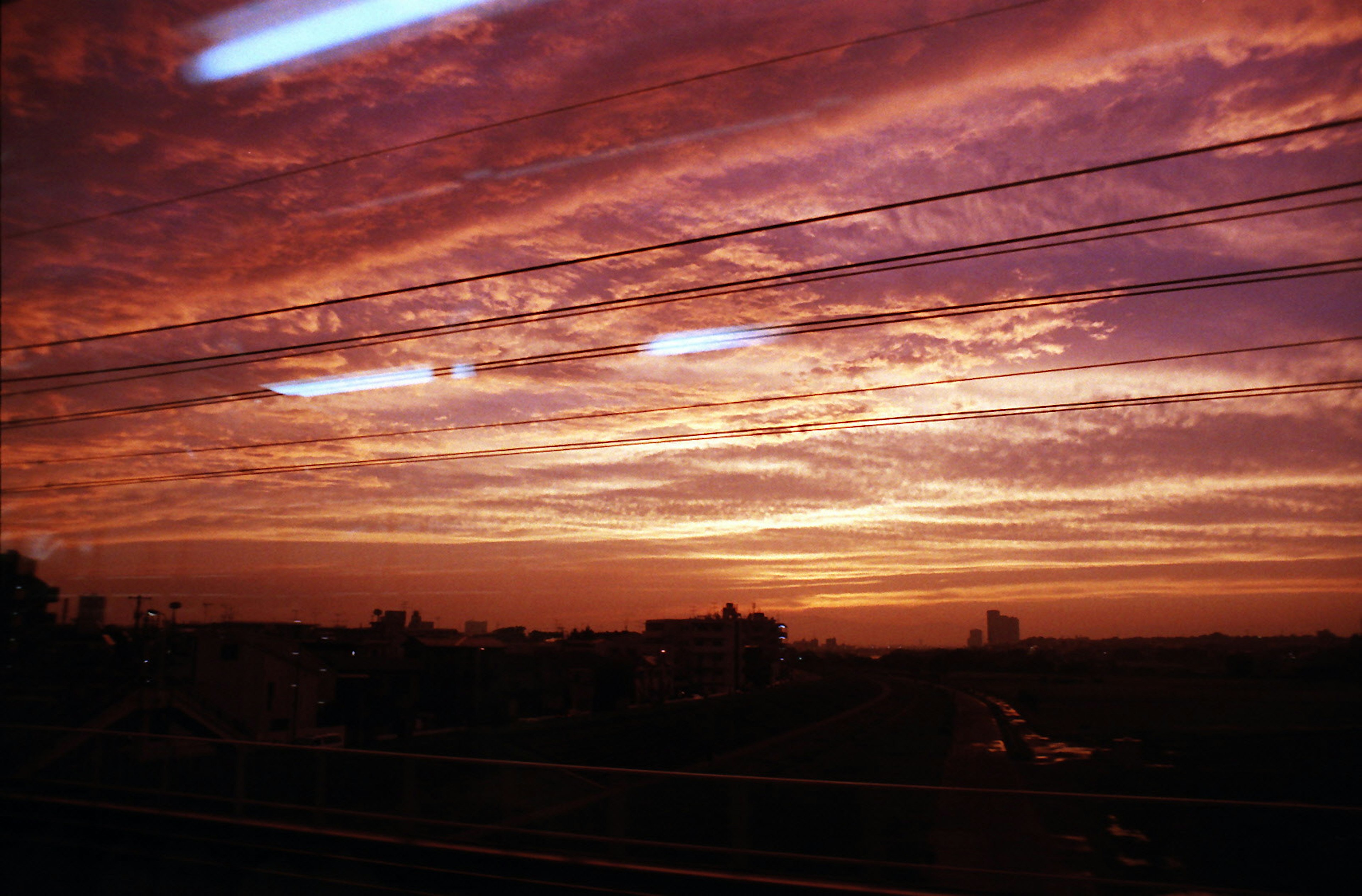 美しい夕焼けの空に広がるオレンジと紫の雲とシルエットの建物