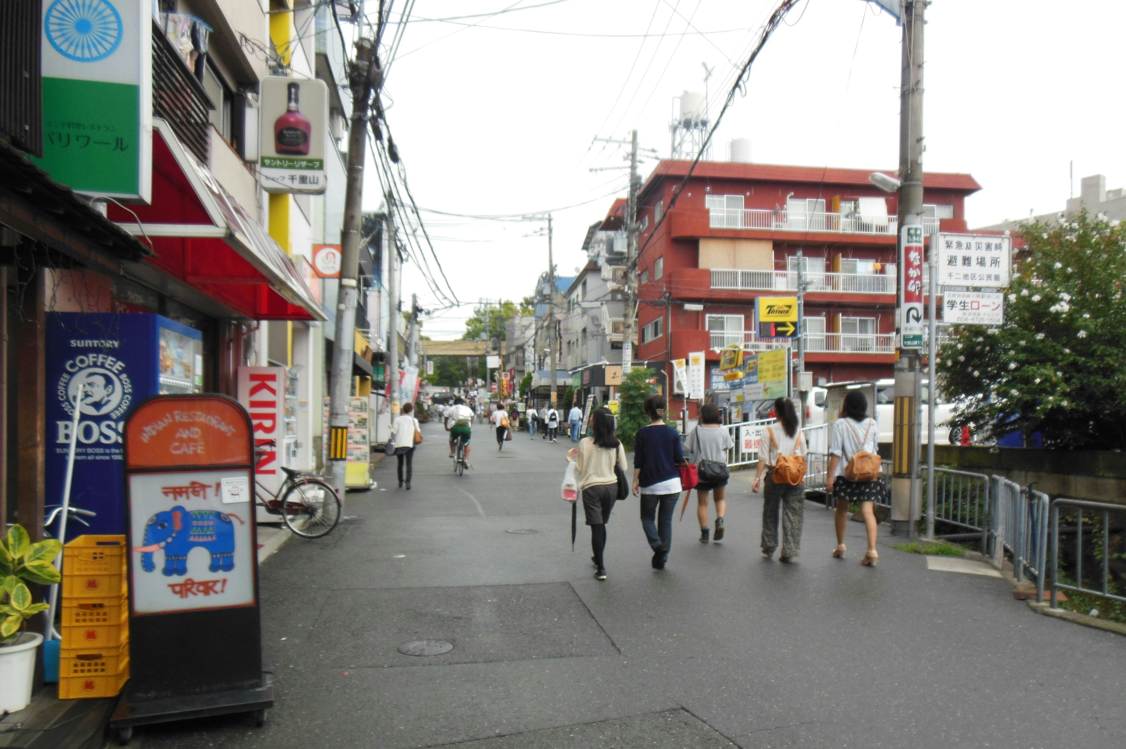 Busy street with people walking Shops and buildings lining the road