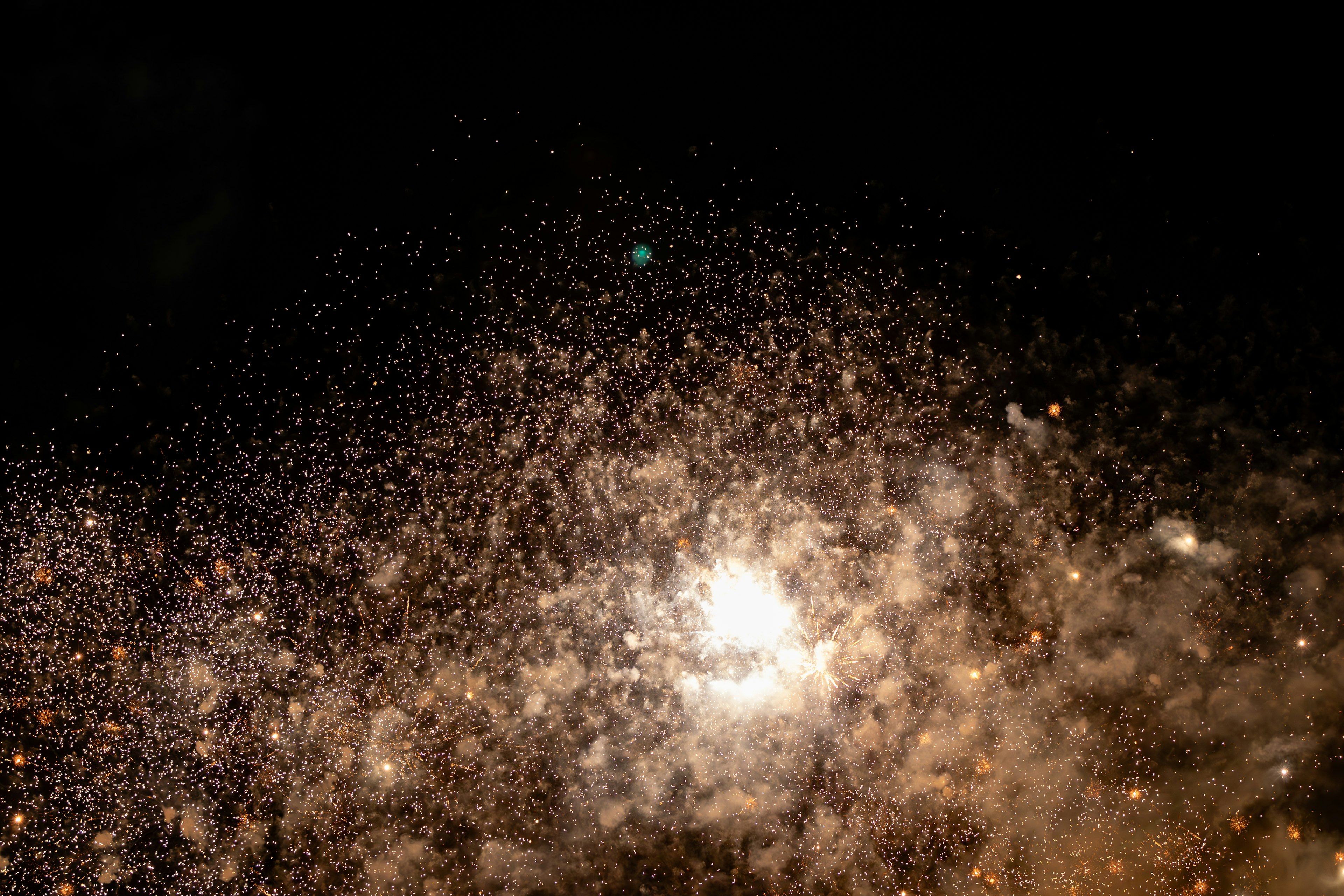 A mesmerizing scene of sparkling particles resembling fireworks against a dark background