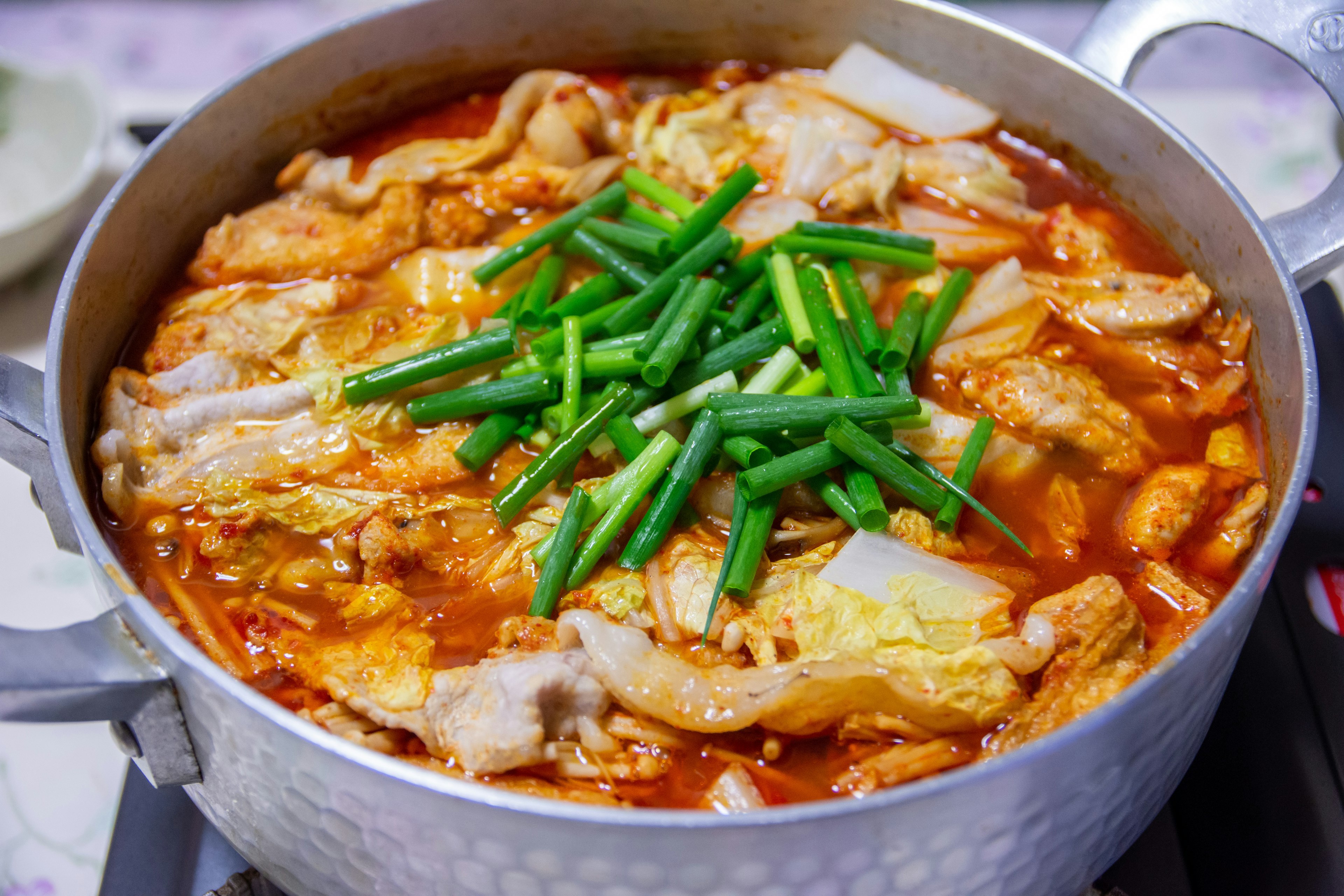 Plat épicé dans une casserole garni d'oignons verts