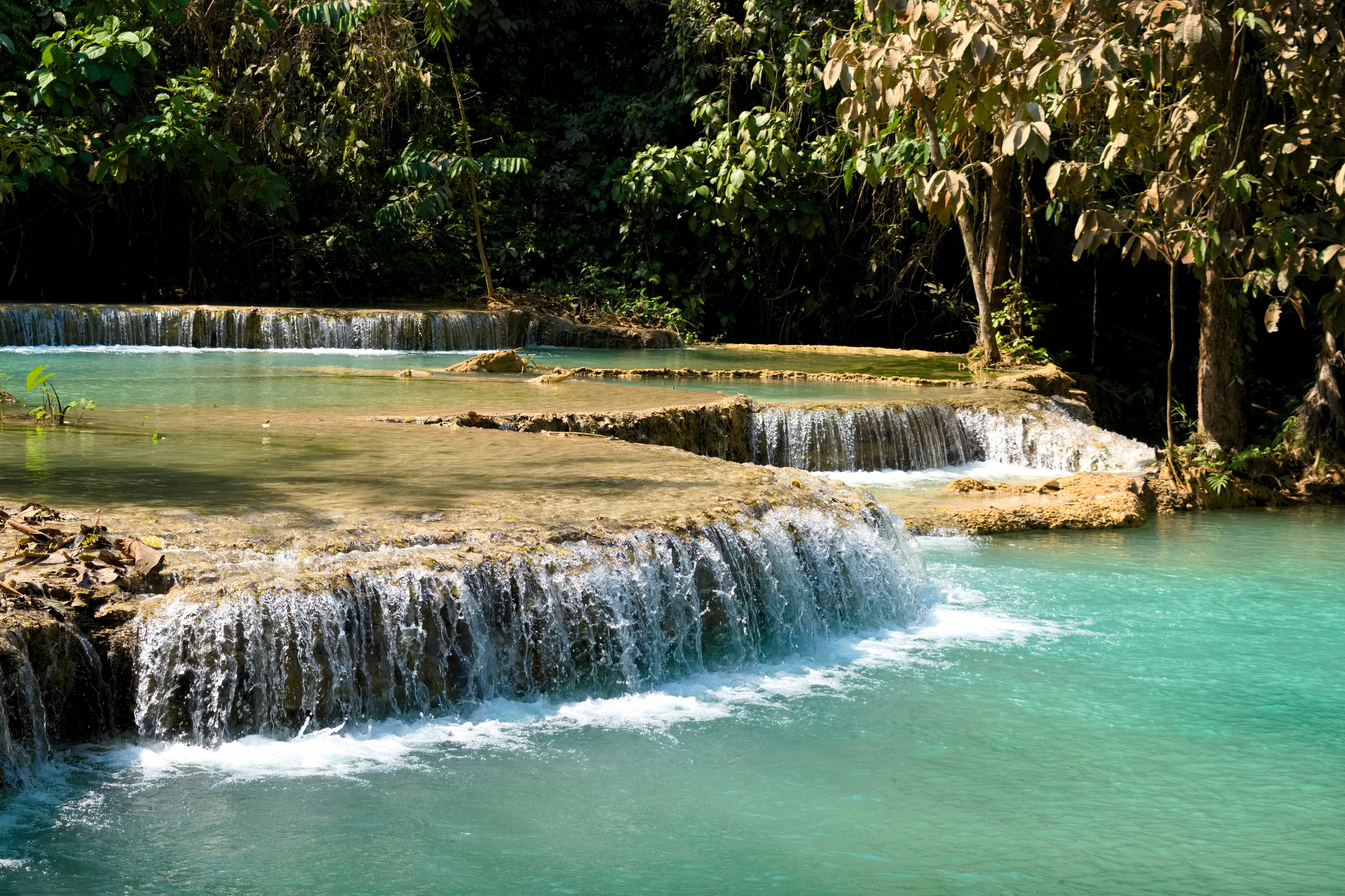 Waterfall with turquoise water surrounded by lush greenery