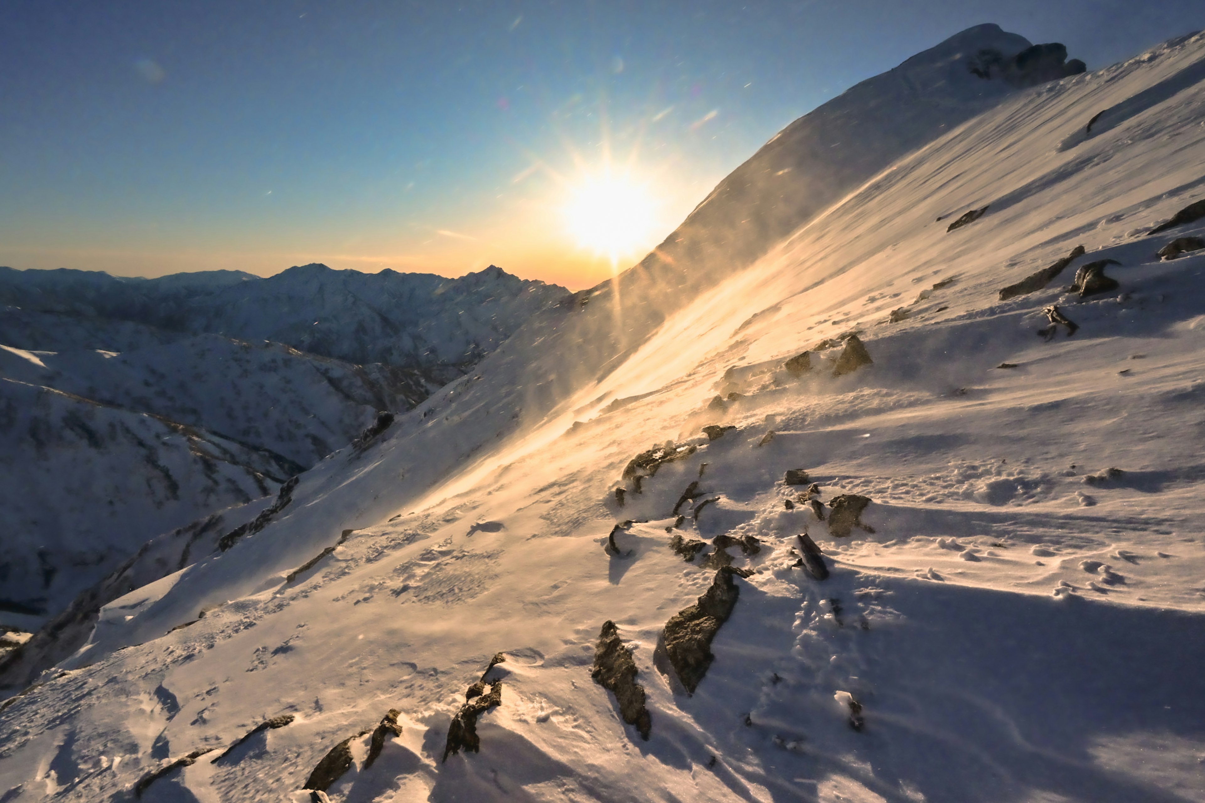 Pente de montagne enneigée avec lever de soleil