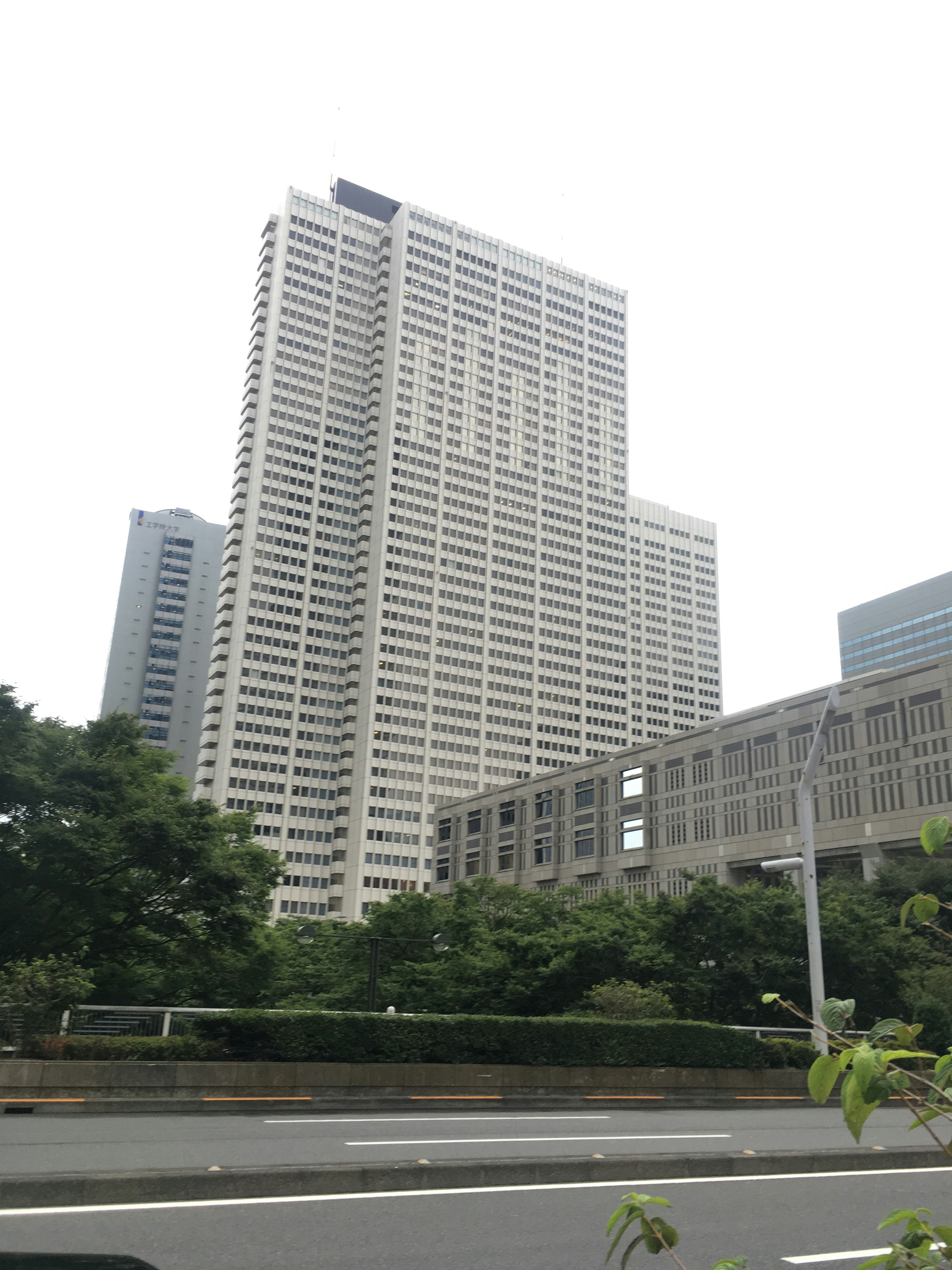 High-rise building with greenery and road in foreground