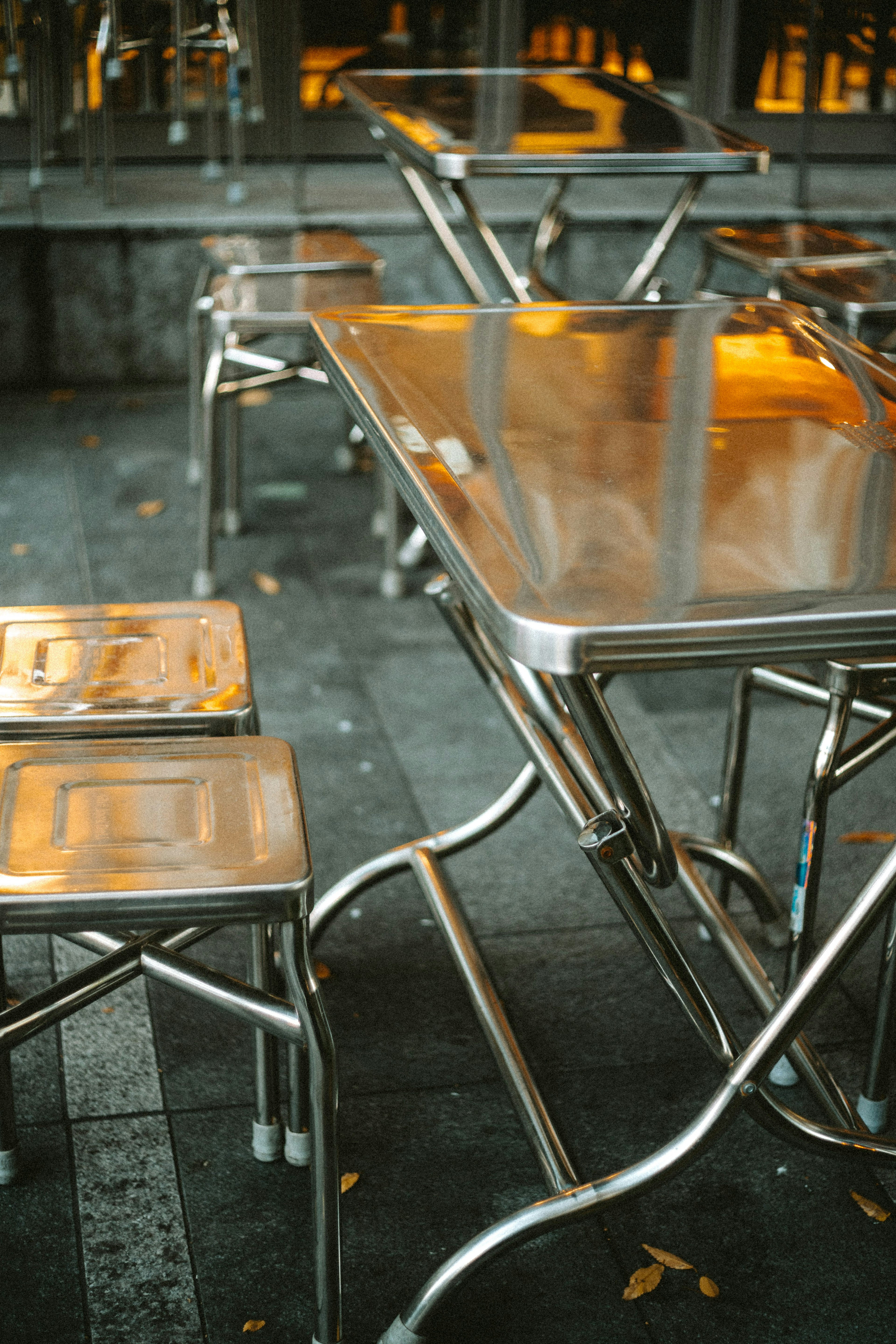 A scene of a stainless steel table and chairs arranged in a cafe