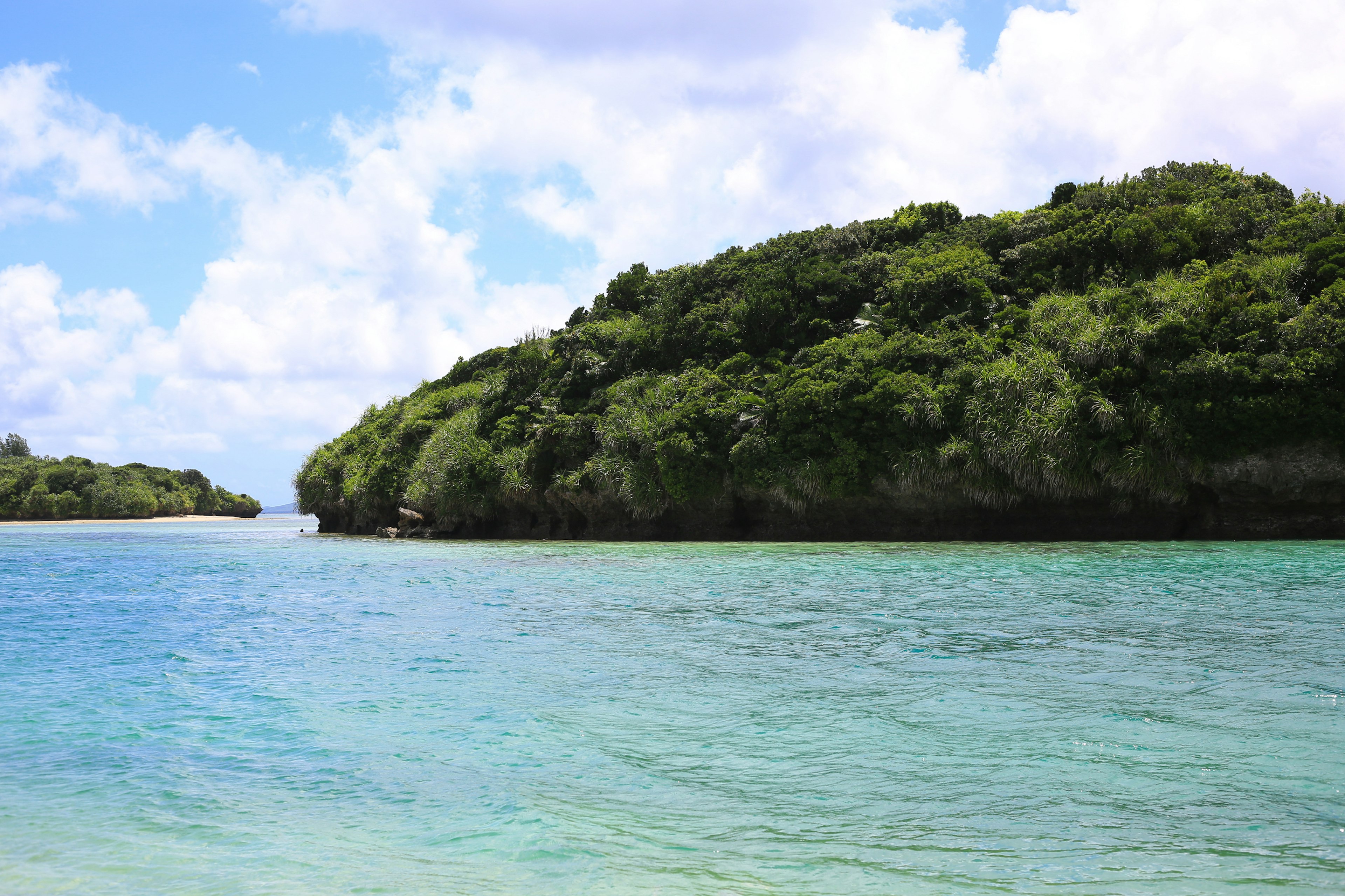 Scenic view of turquoise water and lush green hills