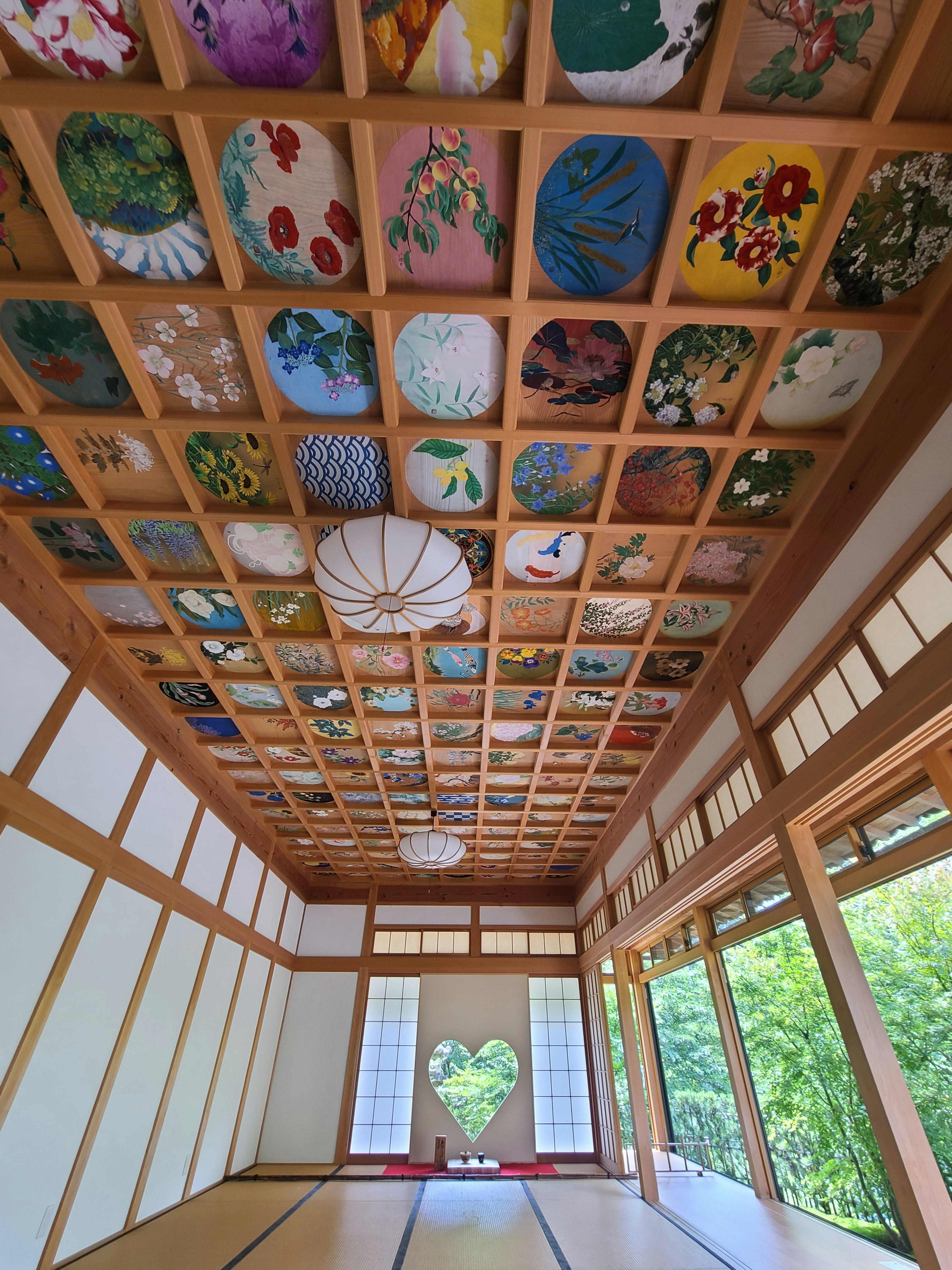 Interior de una habitación tradicional japonesa con un techo bellamente pintado y una ventana en forma de corazón