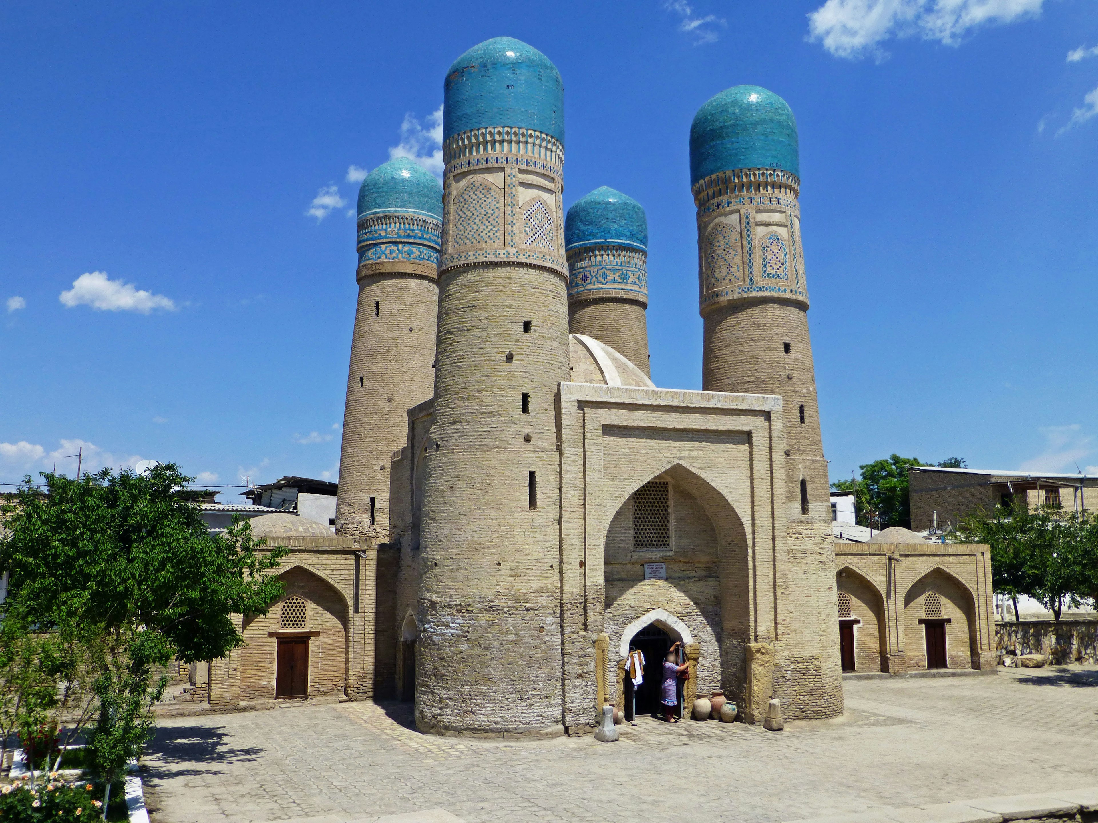 Ancient building with blue domes and surrounding green trees