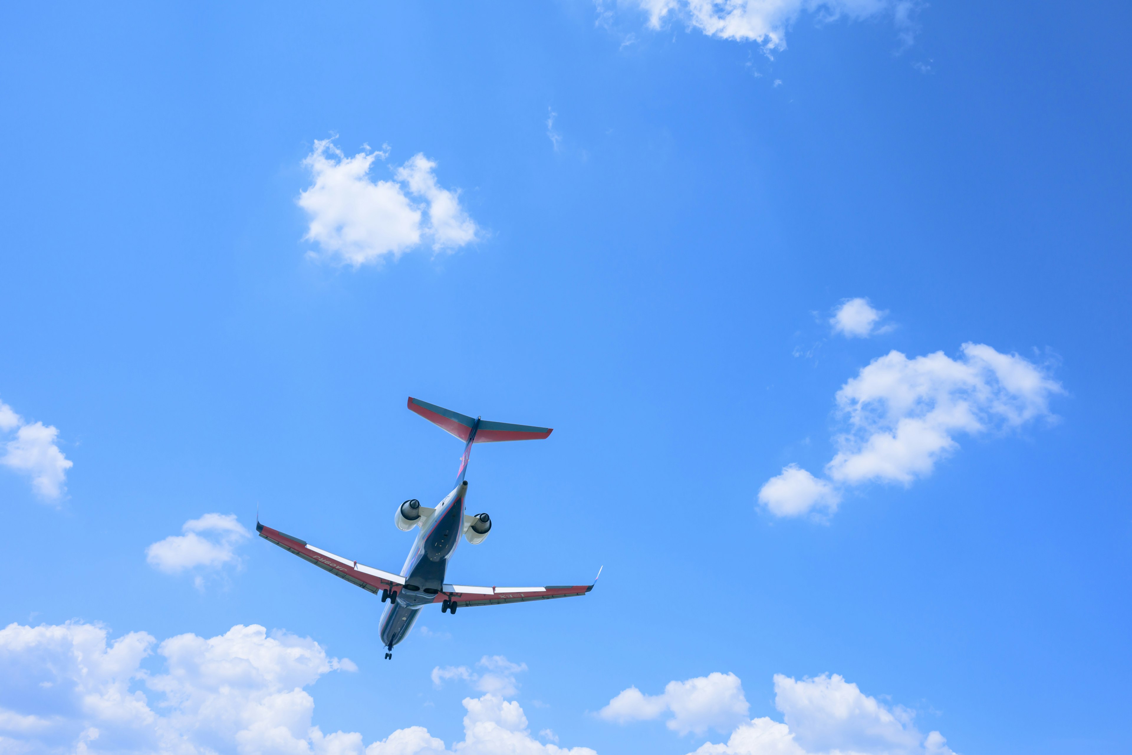 Small aircraft flying in a clear blue sky from below