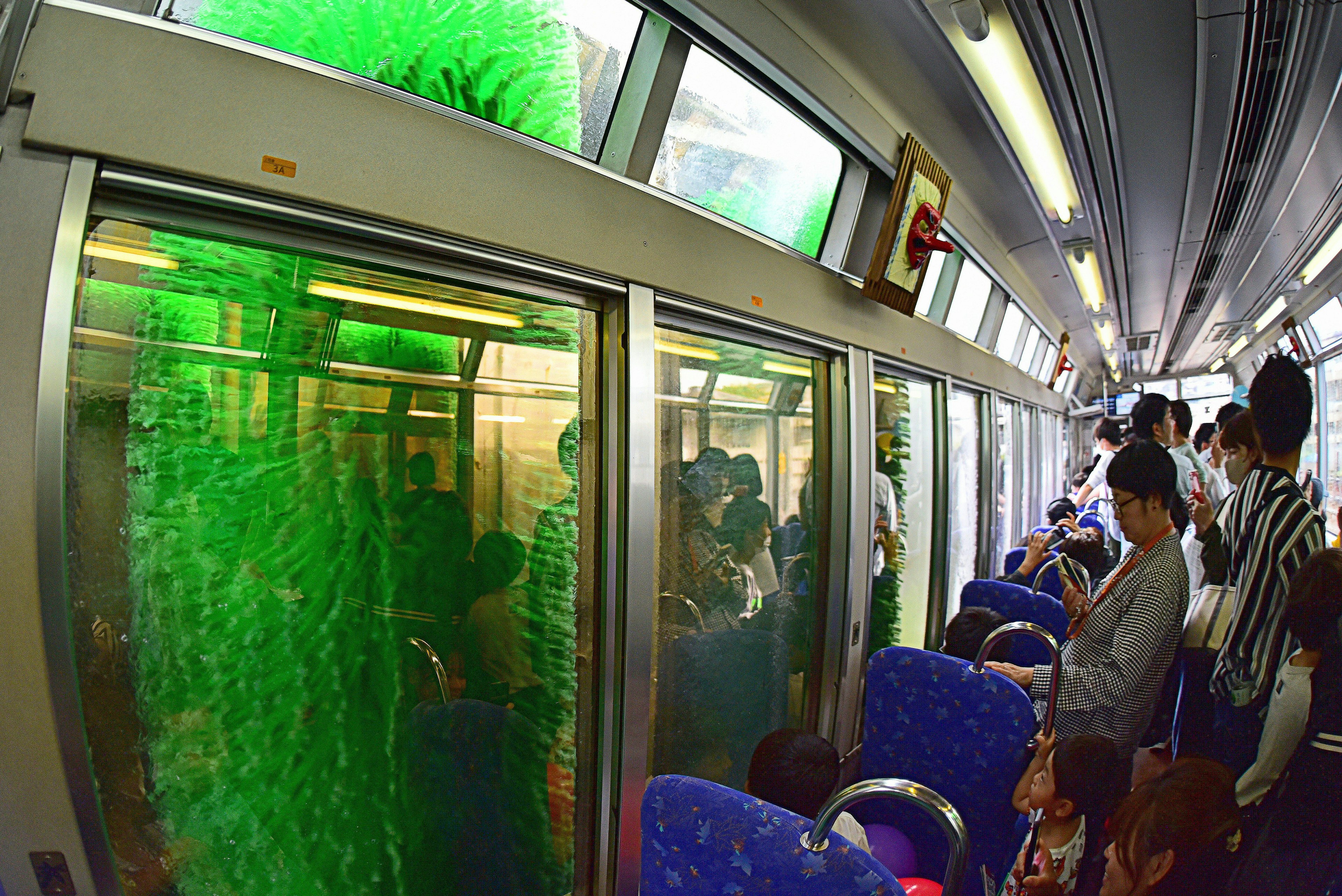 People inside a train with green flowing water visible through the windows