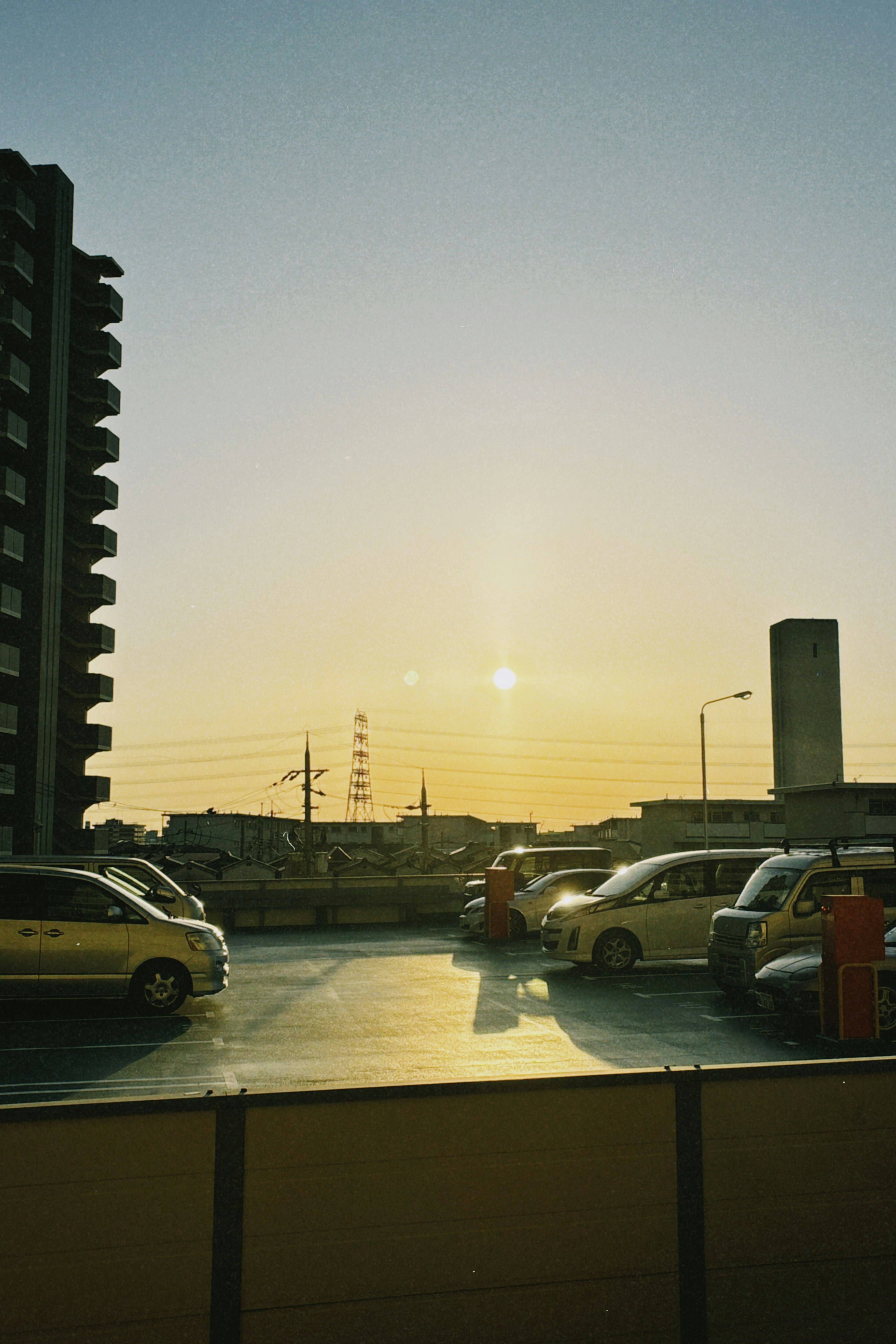 Vista de coches estacionados con una puesta de sol de fondo