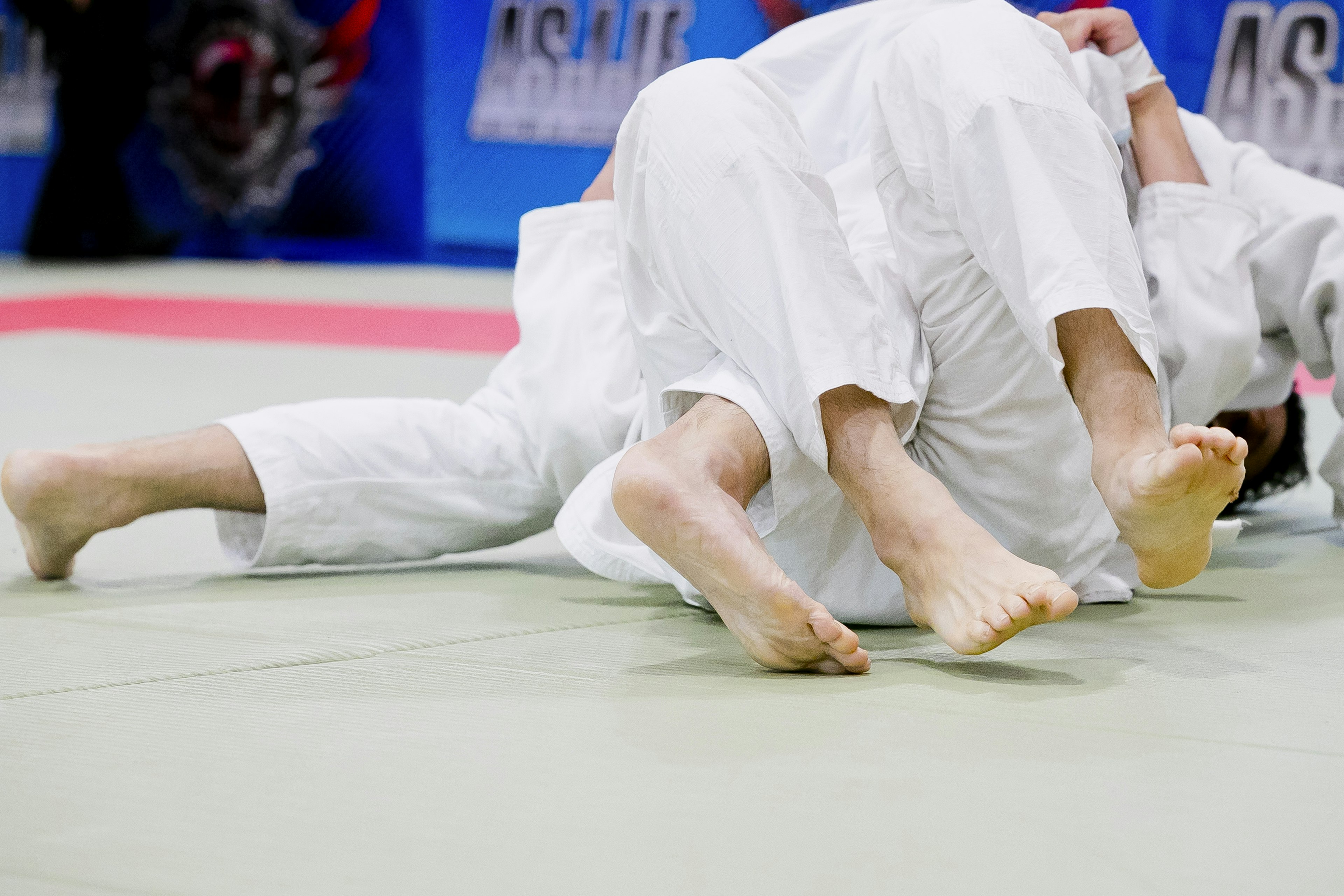 Close-up of judo athletes during a match showcasing their legs and movements