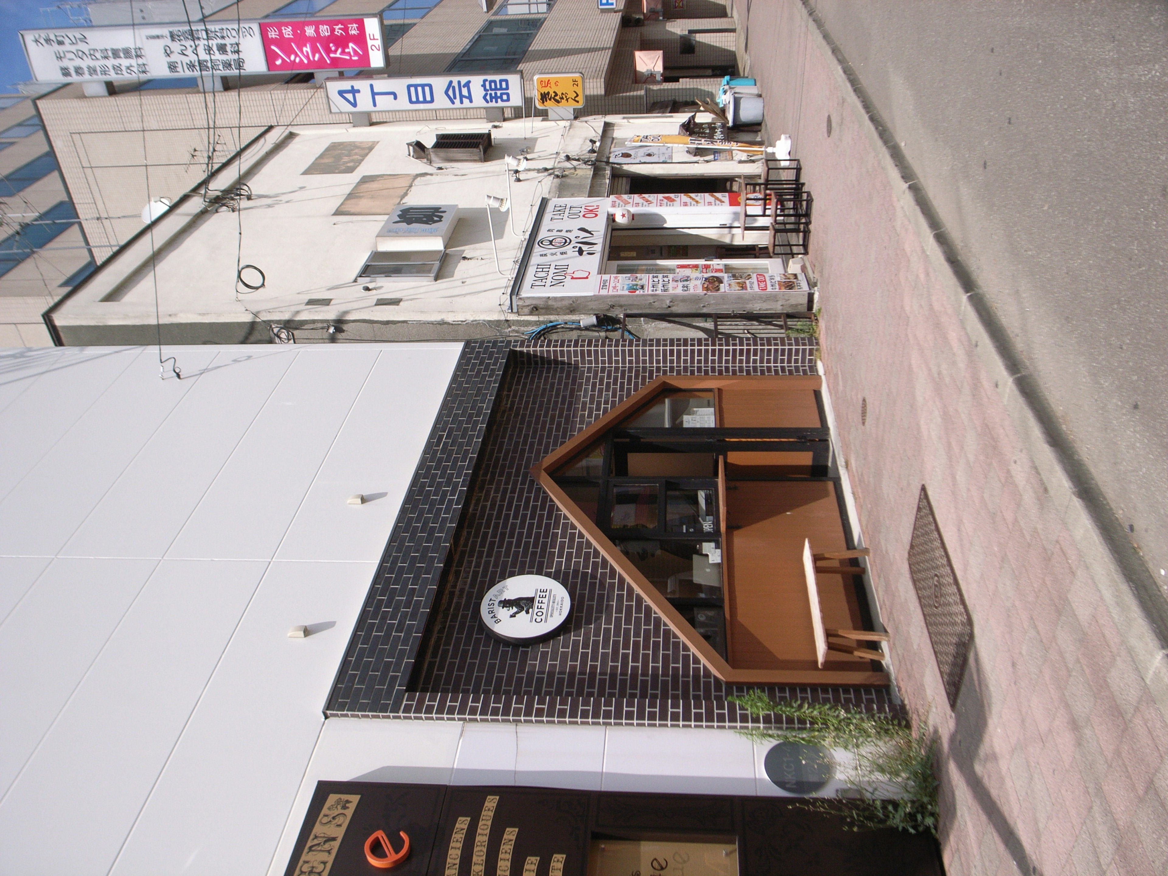 Street view featuring a unique storefront with a tiled roof and wooden entrance