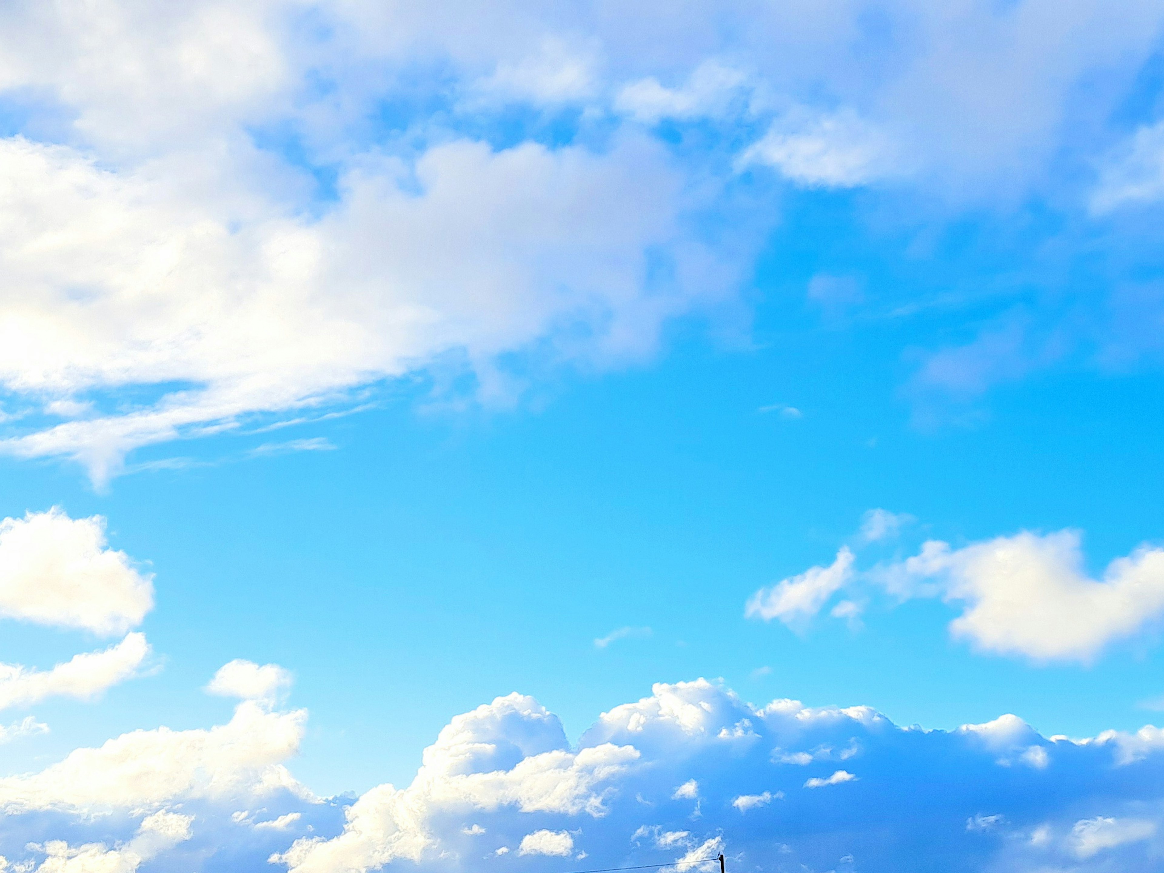 Un ciel bleu lumineux avec des nuages blancs duveteux