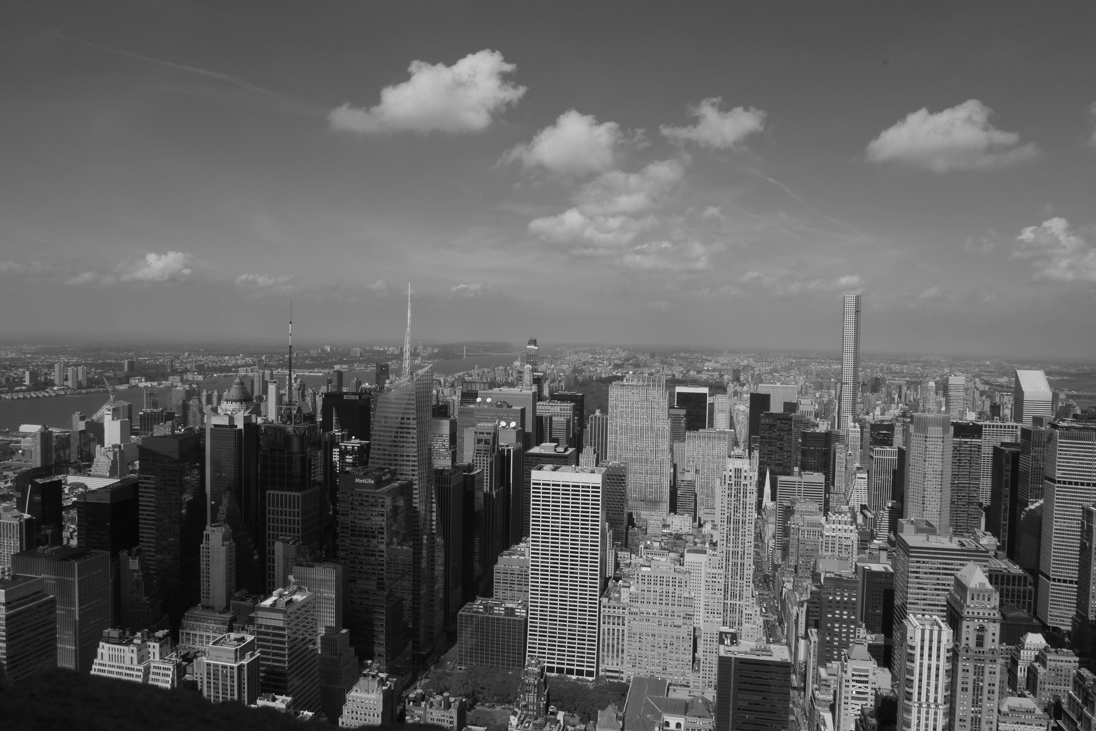 Black and white photo of New York skyline featuring tall buildings and clouds