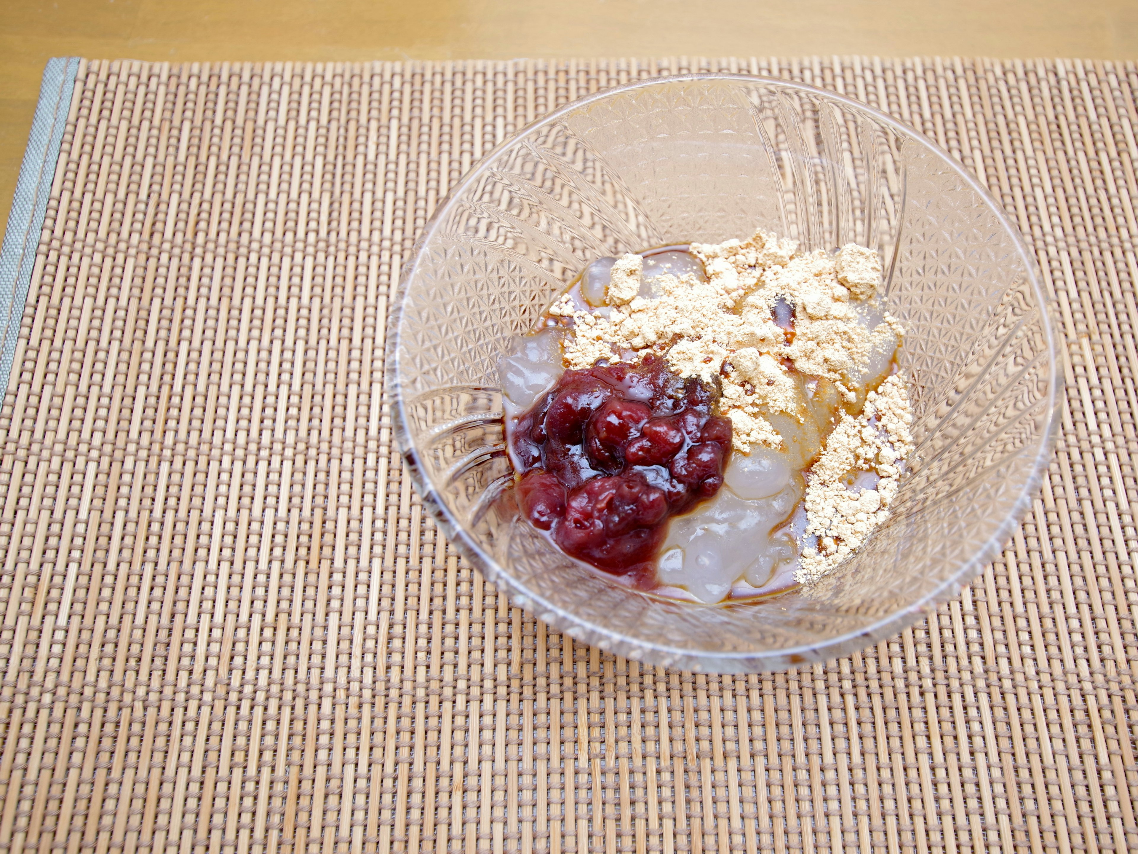 Haferflocken in einer klaren Schüssel mit roter Marmelade