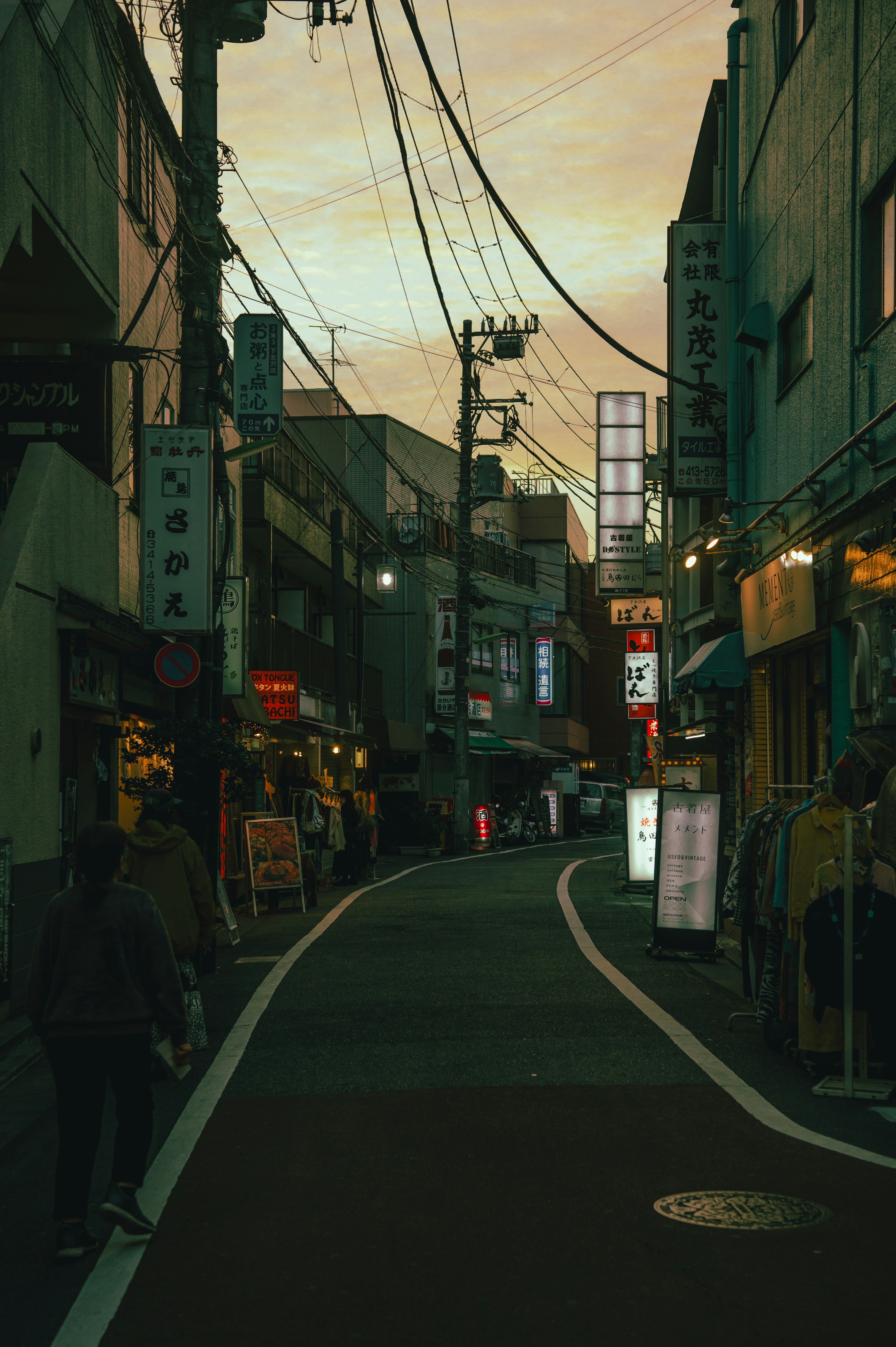 夕暮れの街並みと狭い道路が特徴的な日本の都市風景