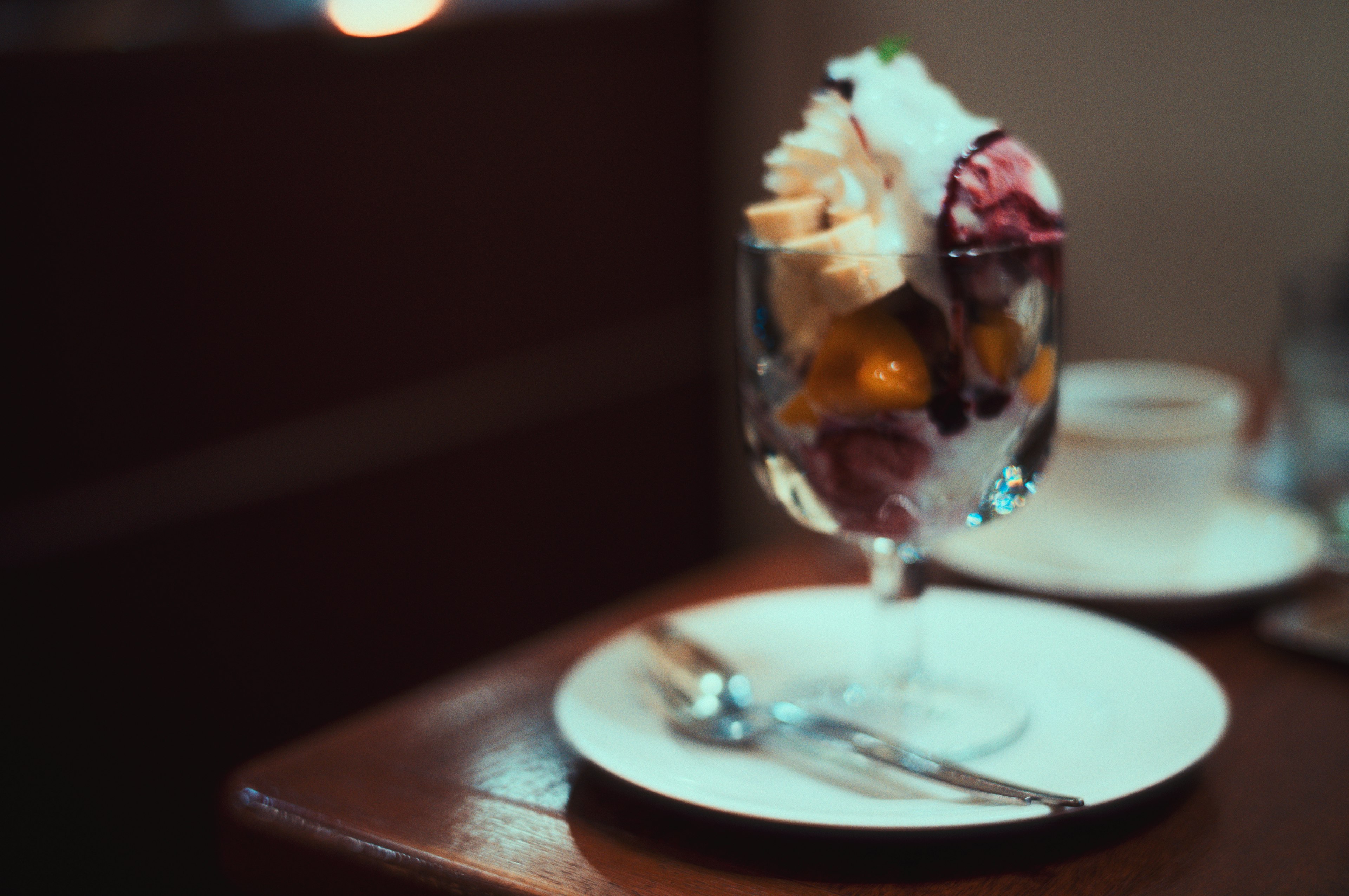 Dessert in a glass featuring colorful ice cream and fruits