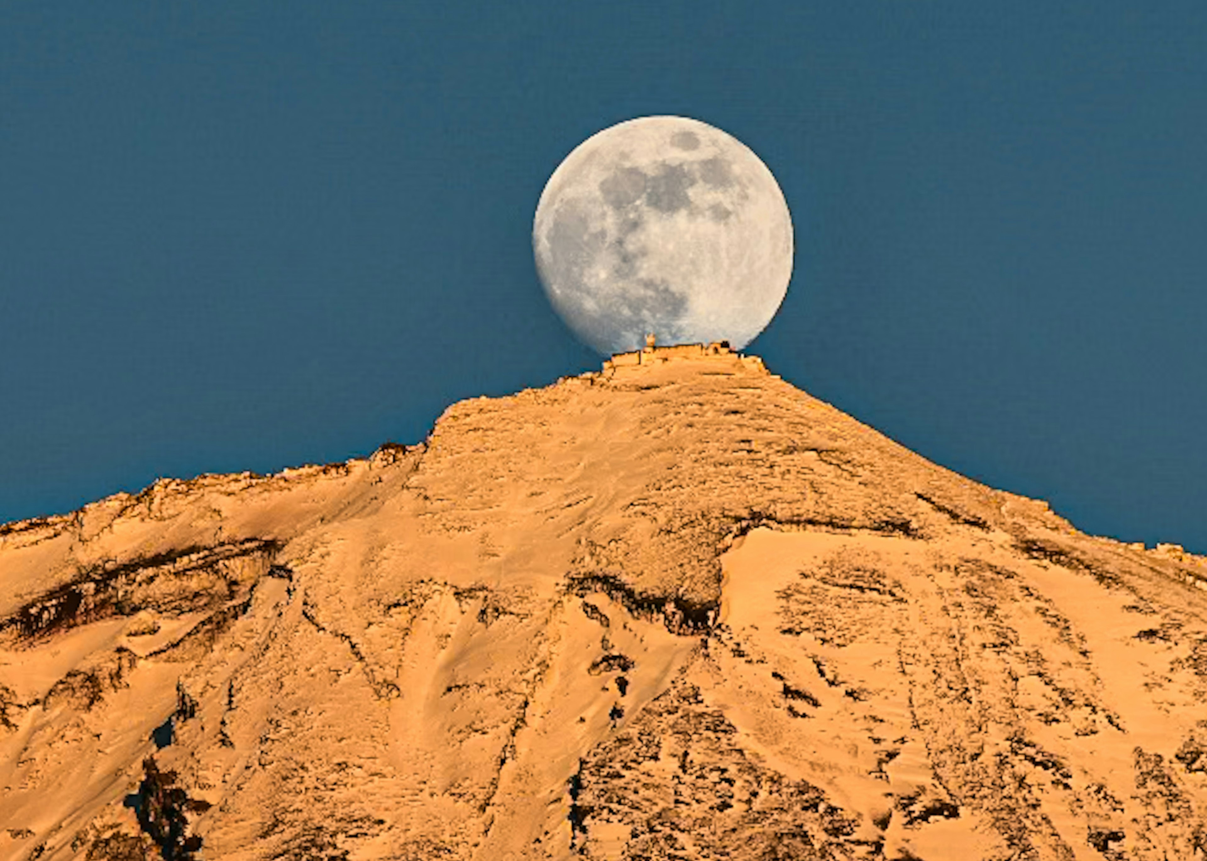 Eine schöne Aussicht auf den Mond, der über einem Berggipfel aufgeht