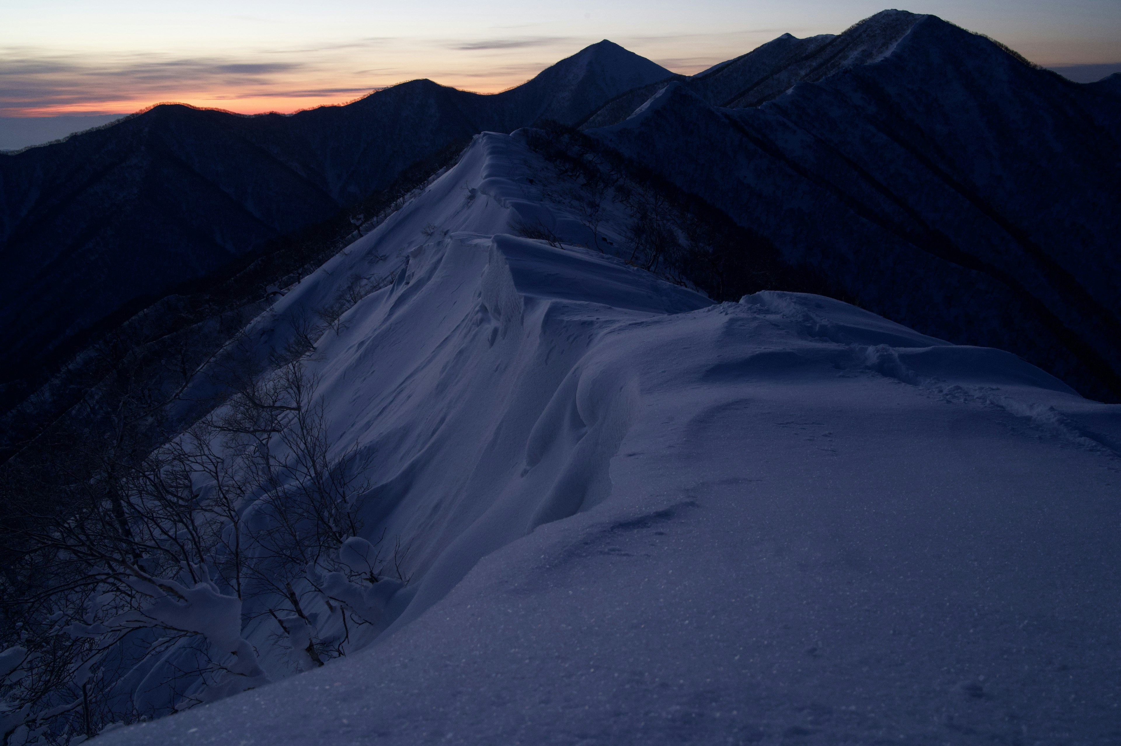 Schneebedeckte Bergkette mit Sonnenuntergangshimmel