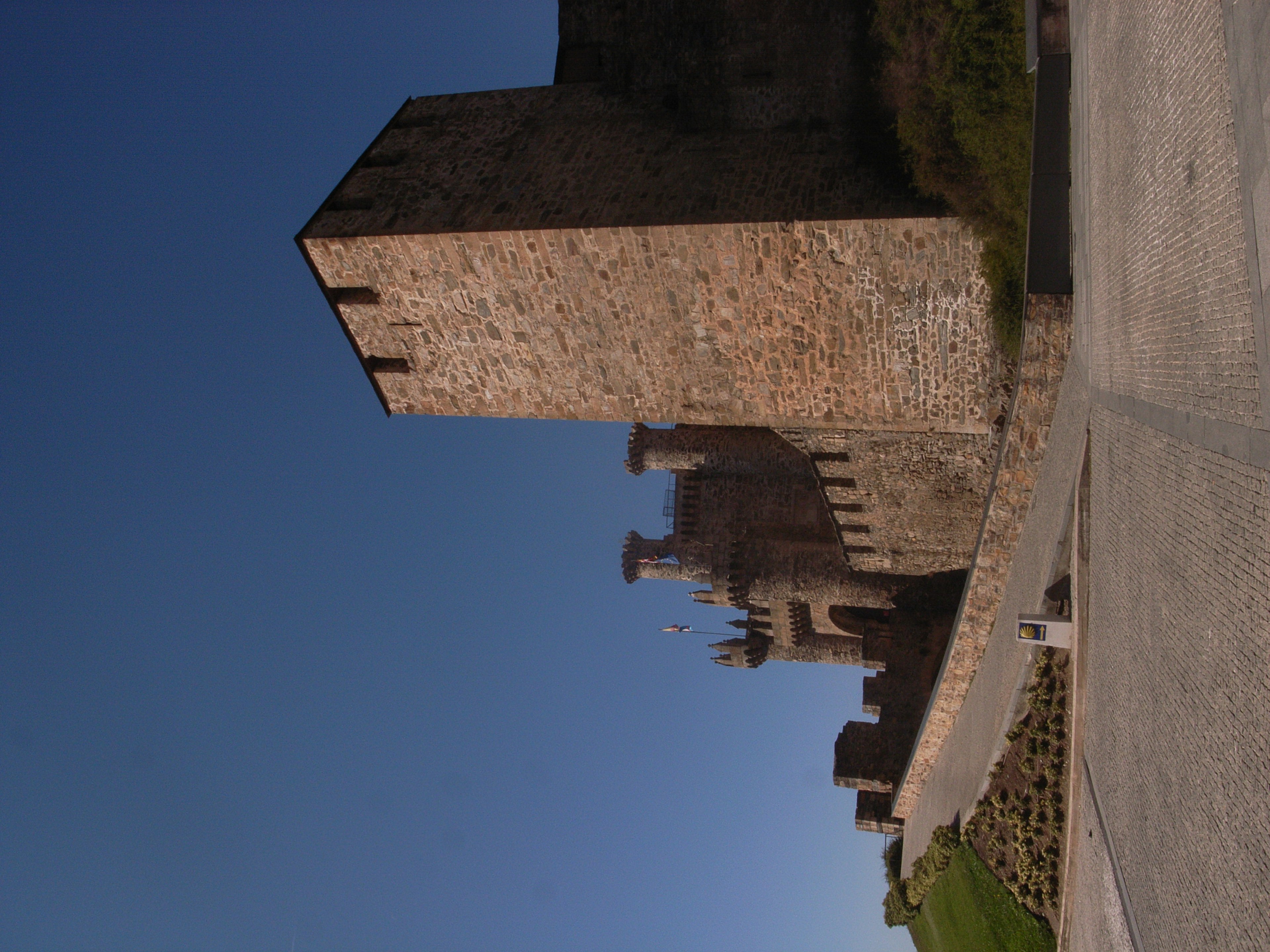 Muri e torri di un castello di pietra sotto un cielo azzurro