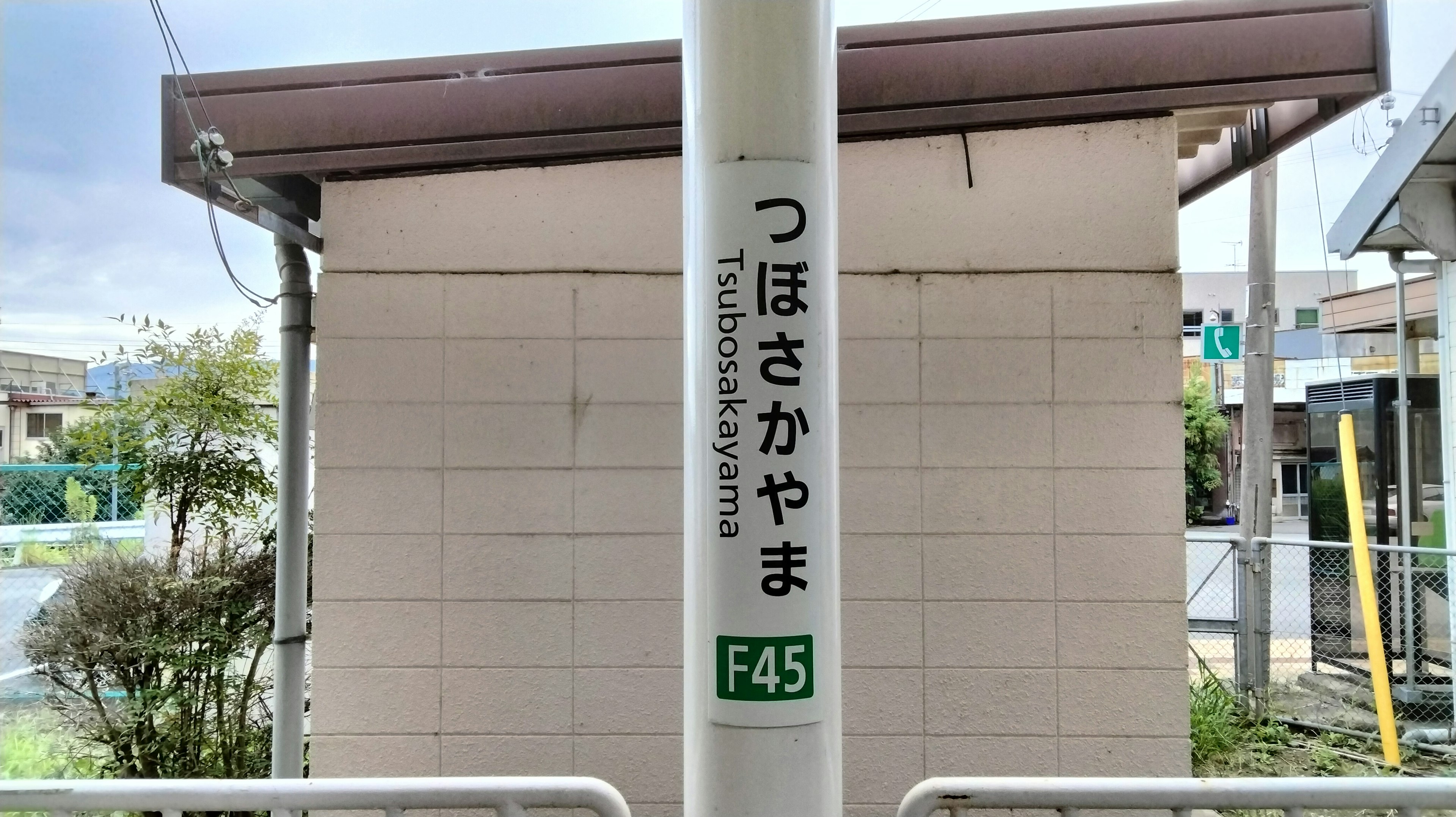 Schild der Station Tsubosakayama mit umliegender Landschaft