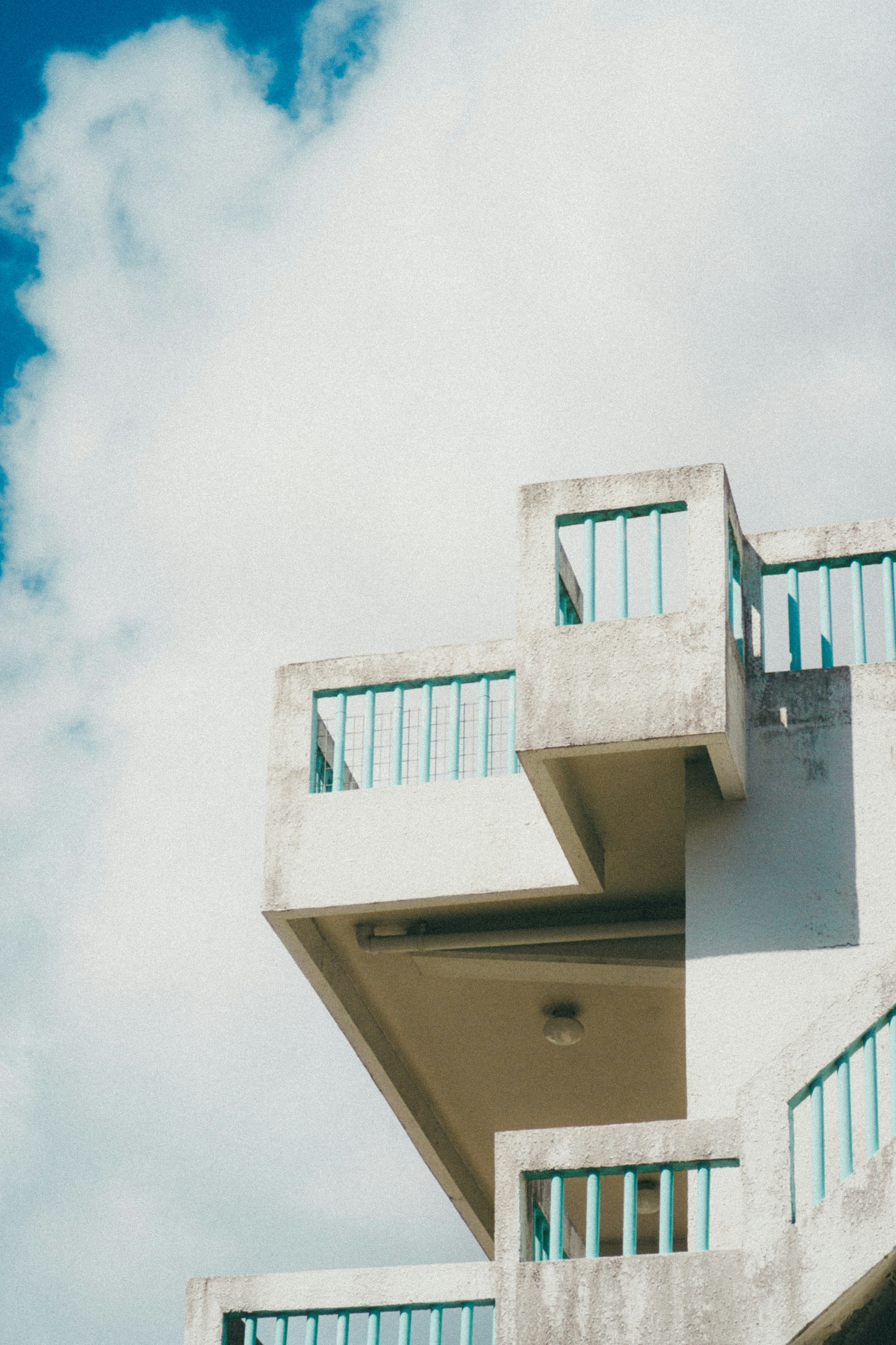 Balkon beton dengan latar belakang langit biru dan awan putih