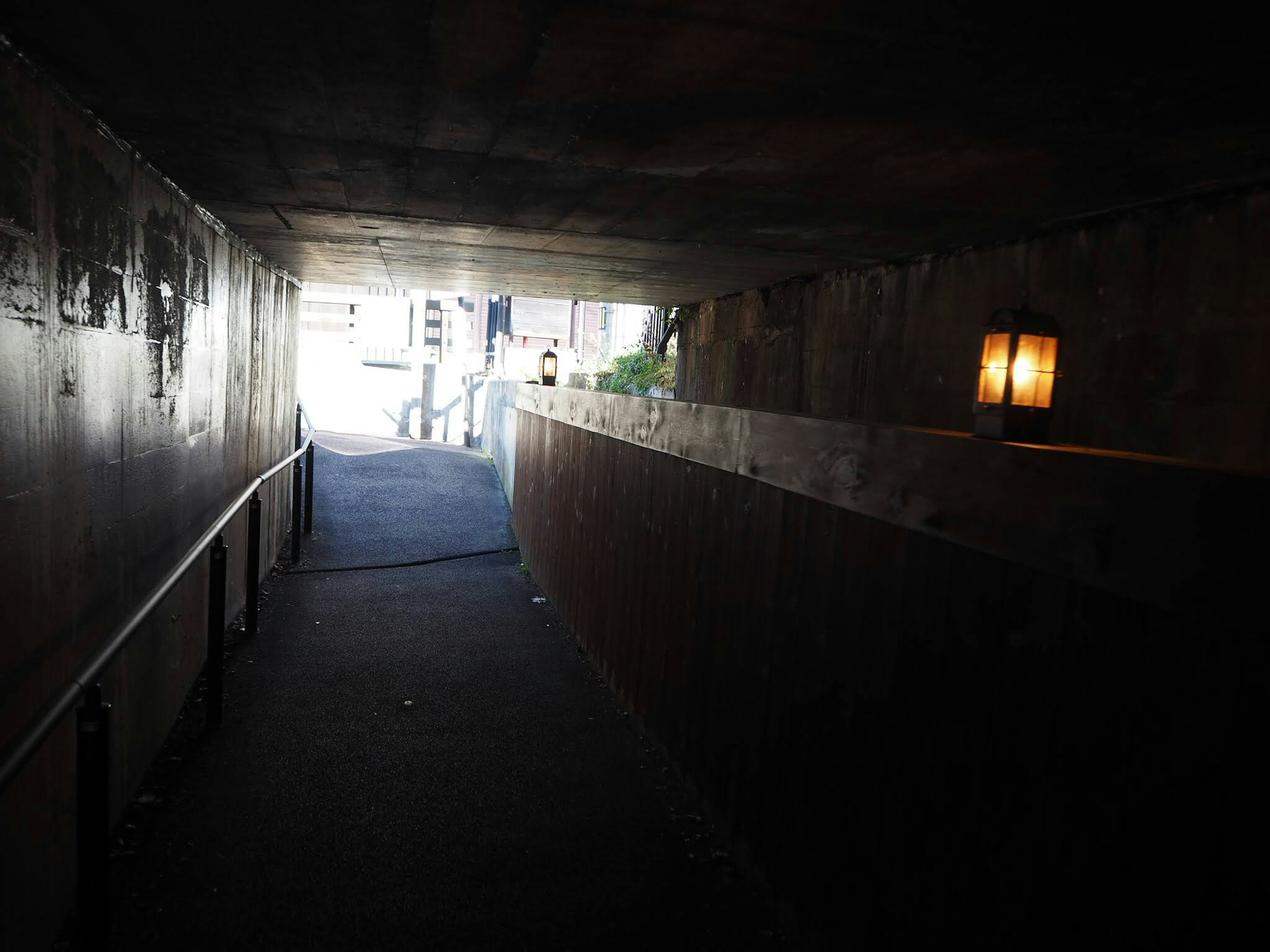 Dimly lit tunnel with a path leading towards bright light