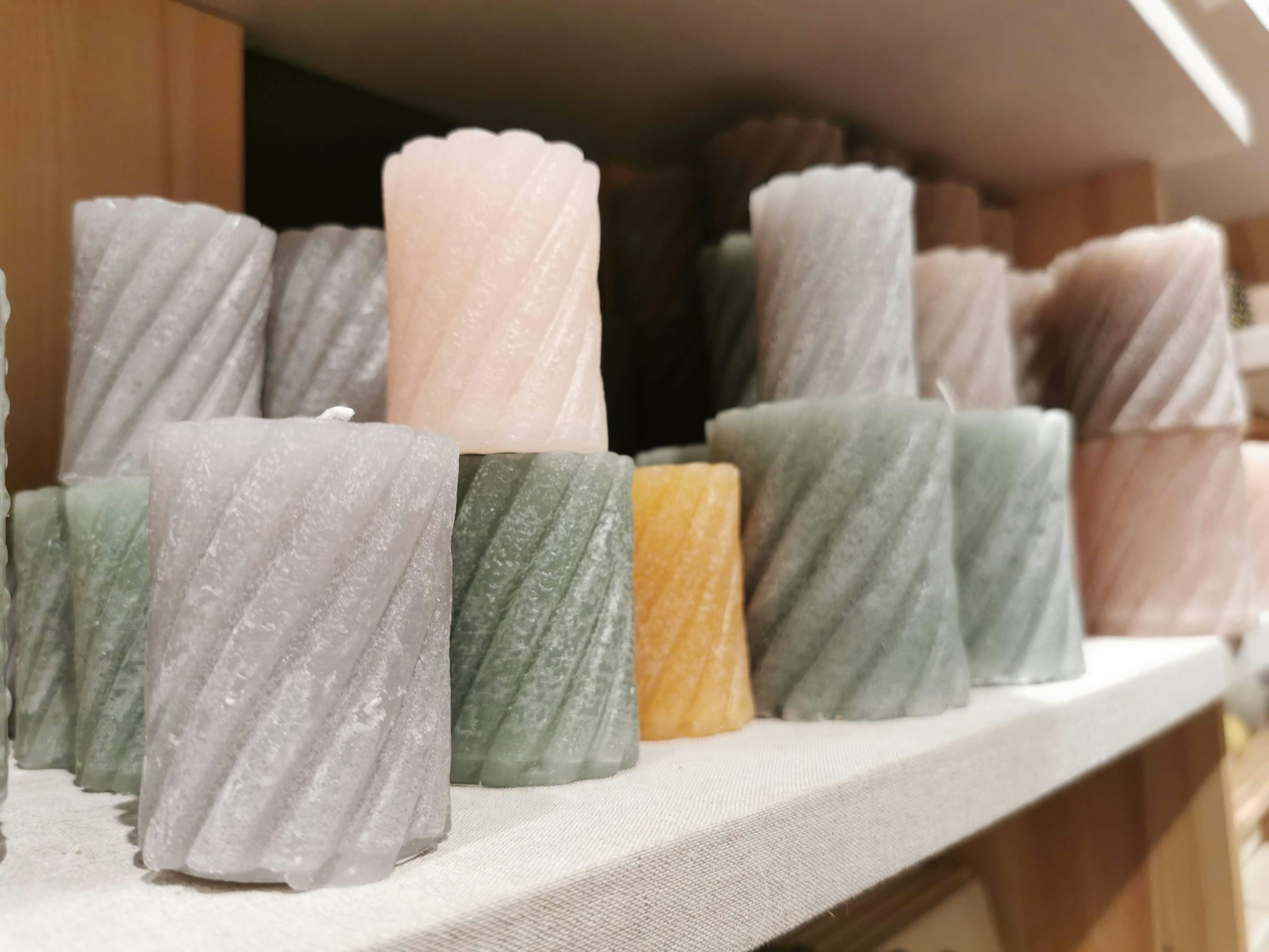 A display of colorful twisted candles on a shelf