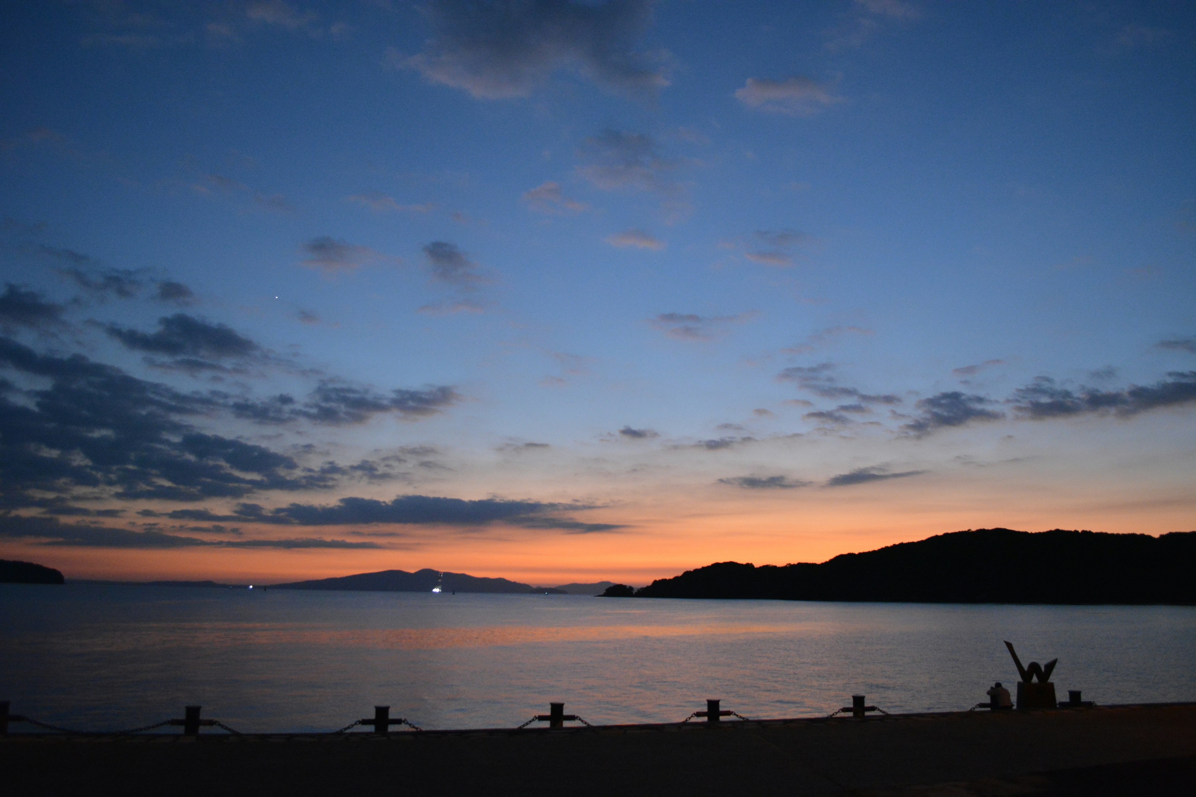 Schöne Landschaft mit Sonnenuntergang über dem Meer und Bergsilhouetten