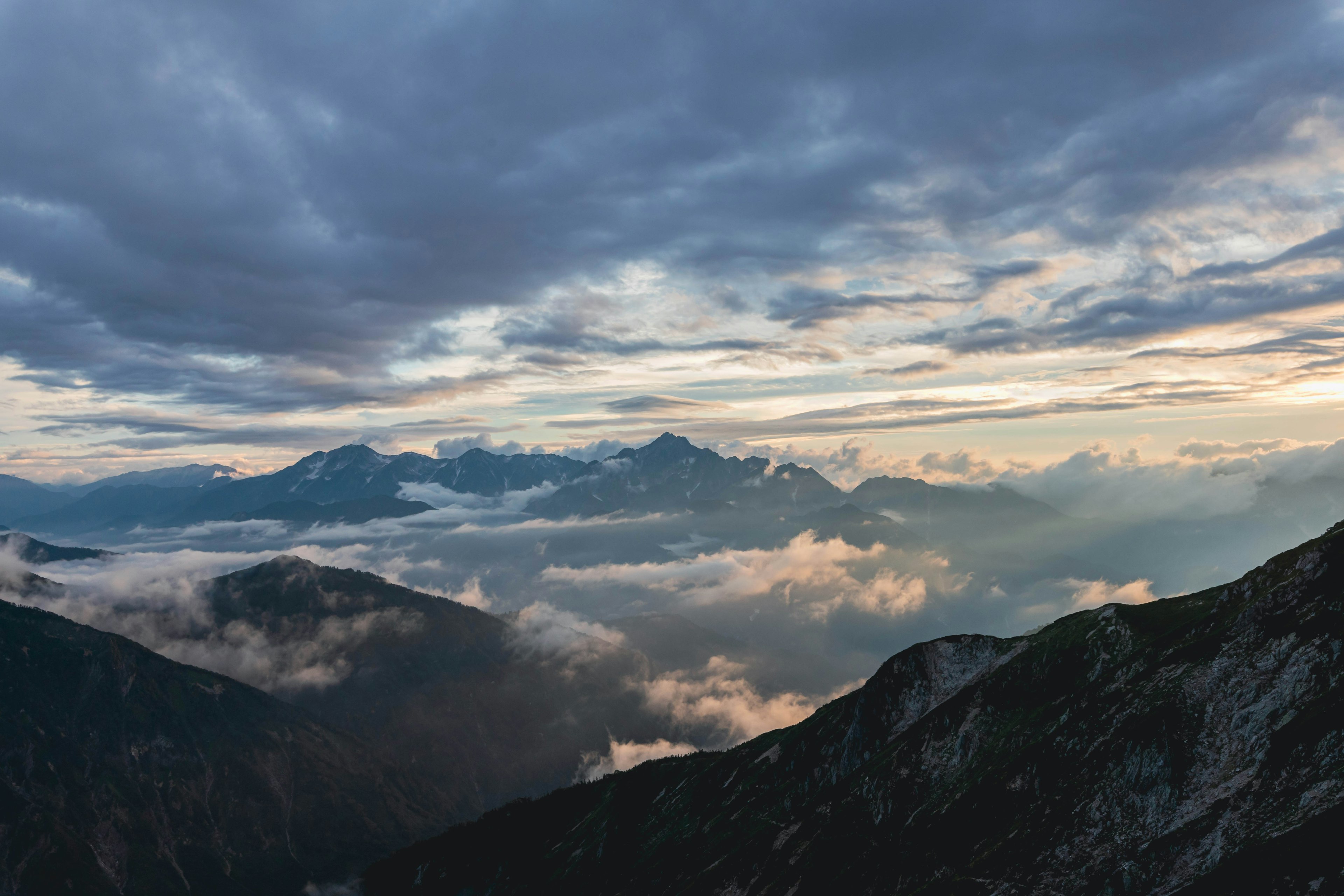 Vista panoramica di montagne con nuvole al tramonto