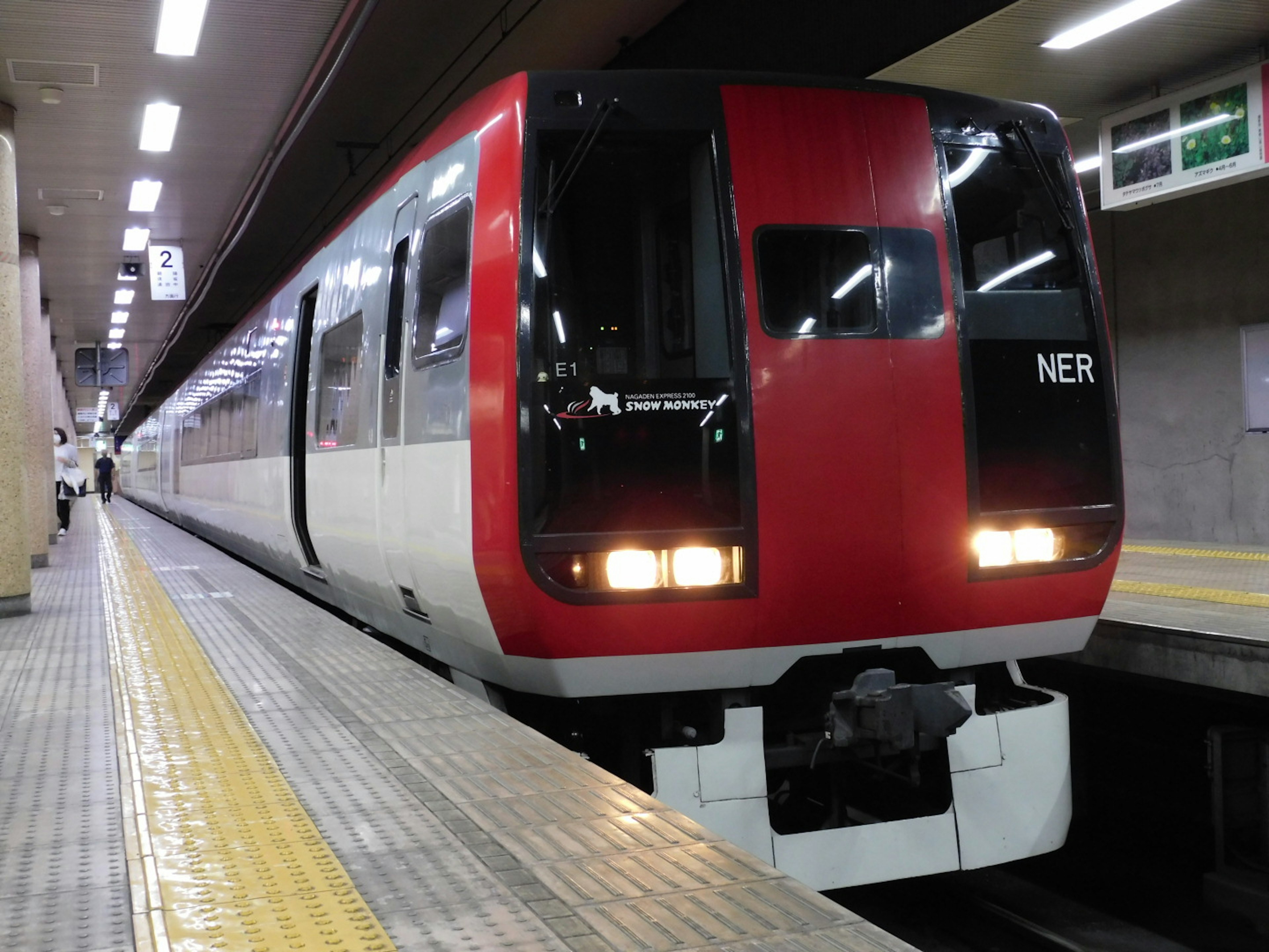 赤いデザインの通勤電車が駅に停車している